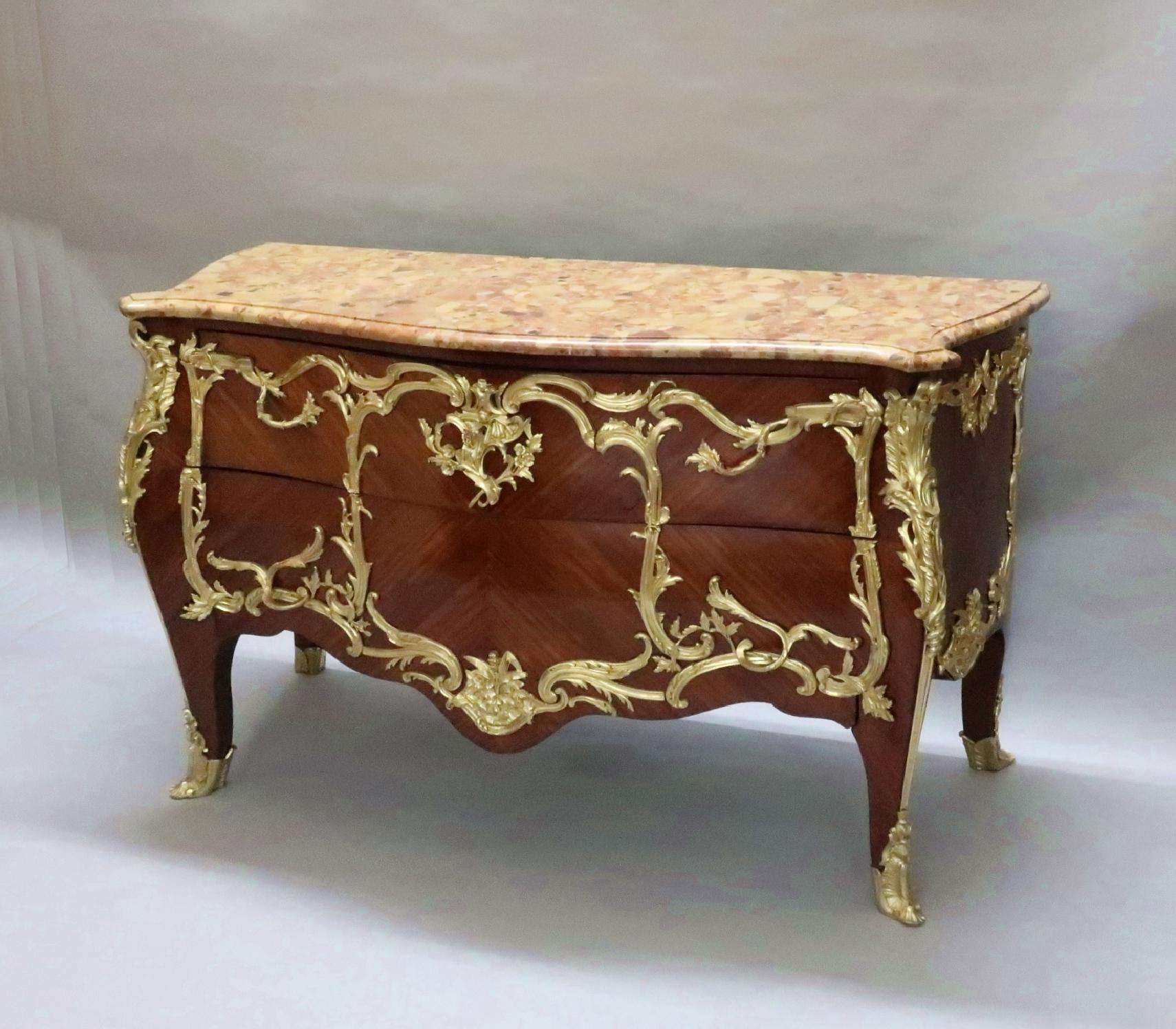 An outstanding French Louis XV style two drawer bombe shaped and serpentine commode chest of drawers by E. Kahn with original Breche d'Alep marble top. The commode has striking satiné quarter veneers and is adorned with exceptional scrolling foliate