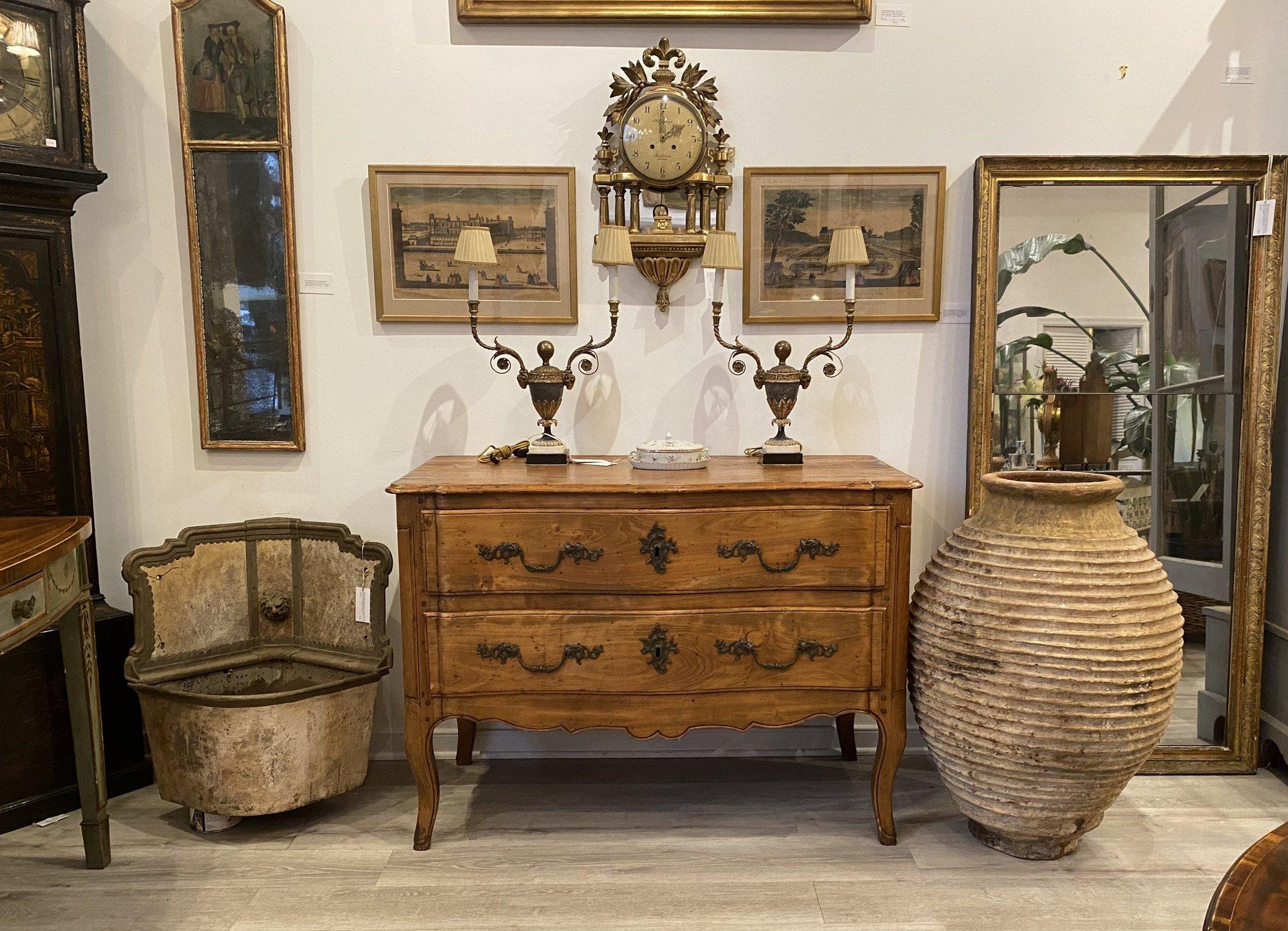Rustic, elegant provincial, 18th century French Louis XV style commode, circa 1800. A serpentine top over two wide drawers over Fruitwood and pine, all original, pegged construction with fine brass dolphin-fish motif pulls. Measures: 34” H x 48” W x