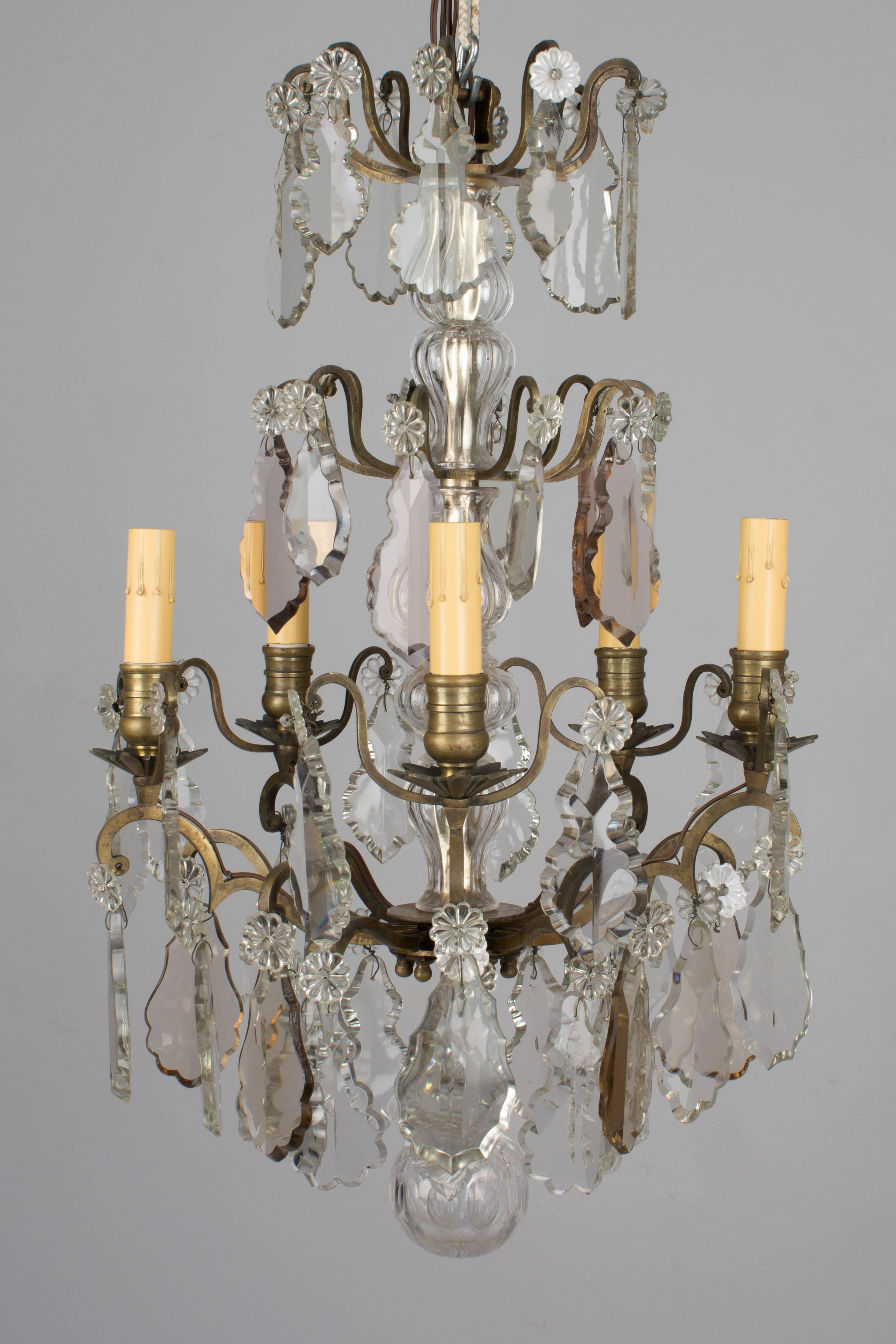 A small French Louis XV style five-light chandelier with an assortment of clear and amber crystal prisms, columns and rosettes. Brass frame. Rewired with new sockets and candle covers. There is no chain or canopy and a ground wire will need to be