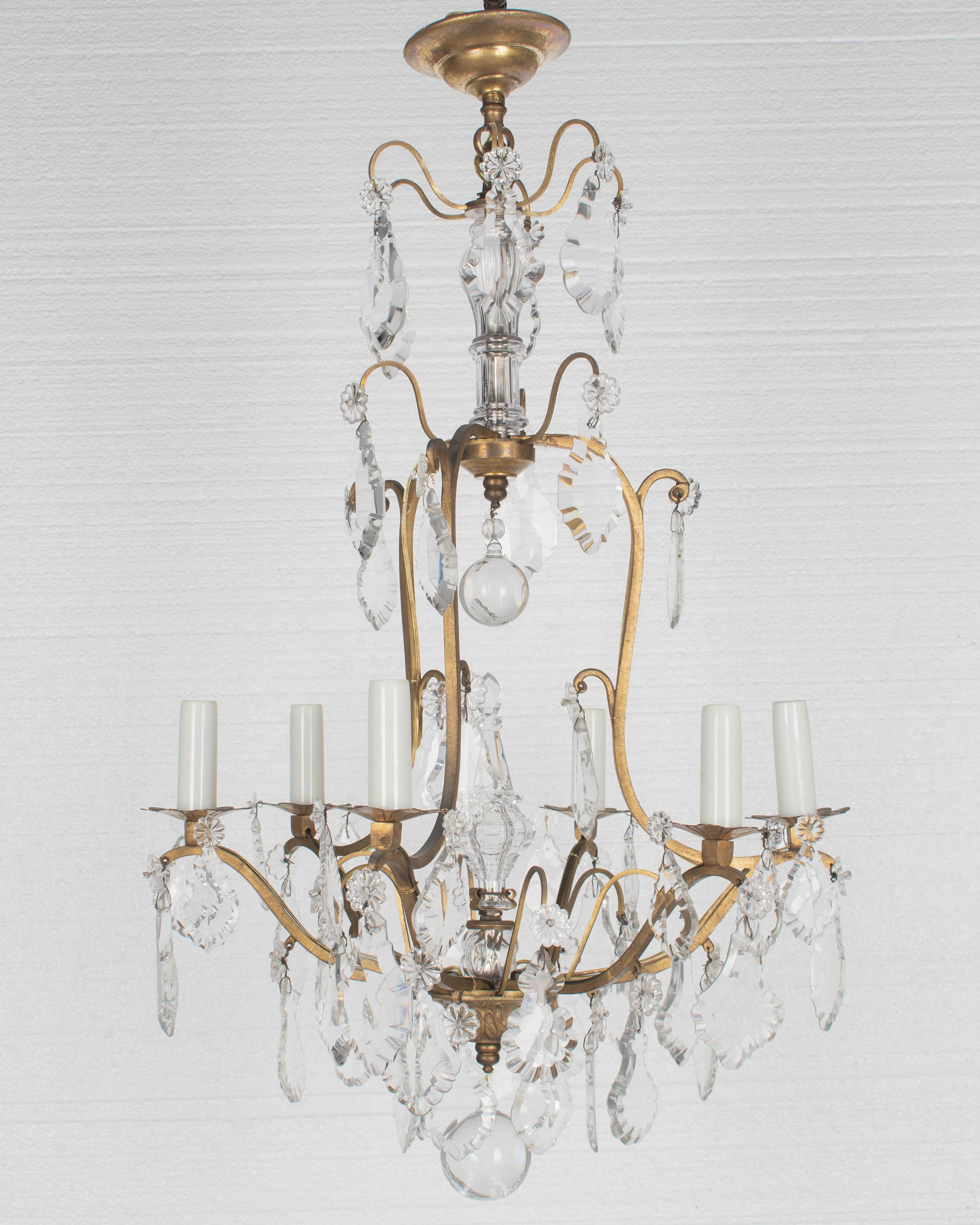 Lampadario francese a sei luci in stile Luigi XV con un assortimento di prismi e pendoli di cristallo con rosette, colonna centrale a coste e grande sfera di cristallo tagliato. Struttura in ottone massiccio con bobeches in ottone fuso, cristalli