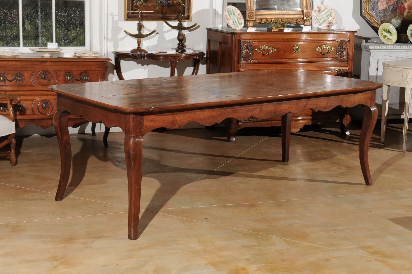 A custom made French Louis XV style dining table from Lyon made from 19th century parts, with parquetry top, carved apron and cabriole legs. Crafted in the Rhône Valley from 19th century wood, this Louis XV style dining table will comfortably seat 8