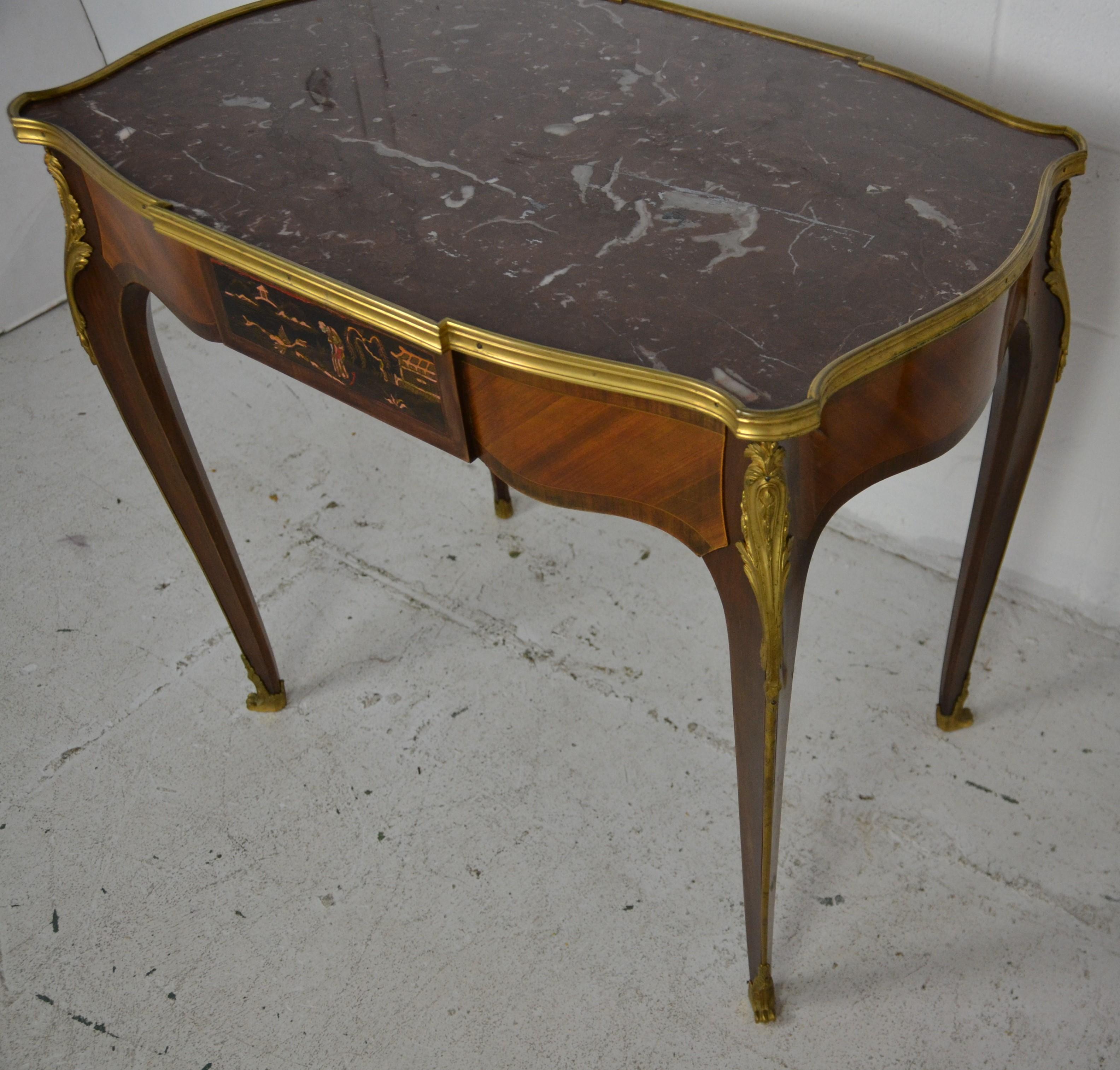 A French Desk in the Louis XVI style with an inset marble top surrounded by a polished brass / bronze edging. A full length drawer with painted Chinoiserie front. ( matching the reverse side) Gilt decorations to the legs with an Acanthus leaf
