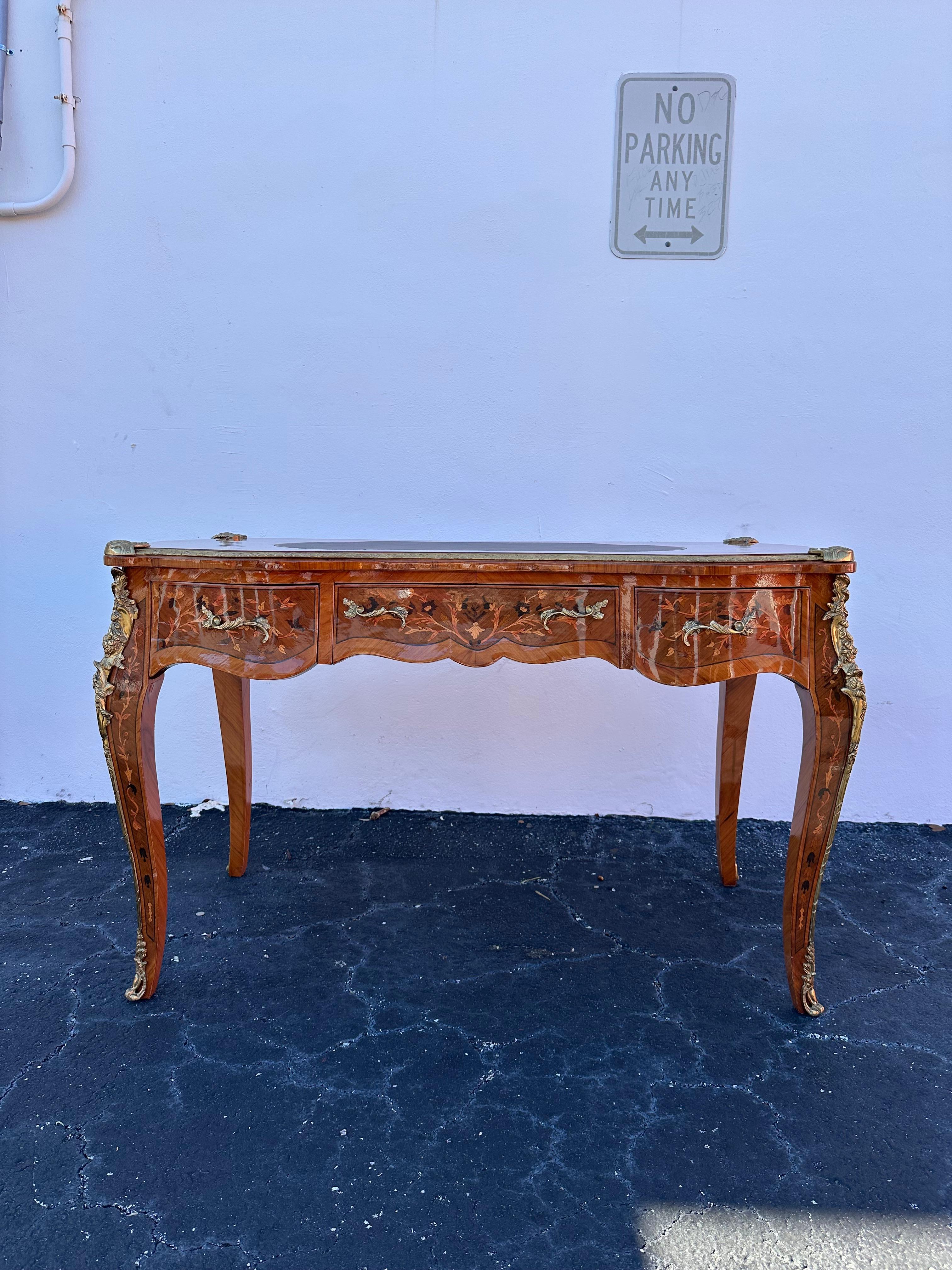 Questa scrivania in stile francese incarna la raffinata eleganza dello stile Luigi XV, rendendola un'aggiunta senza tempo a qualsiasi spazio.
Realizzata in legno massiccio, la scrivania presenta un piano dalla forma aggraziata e ornato da delicati