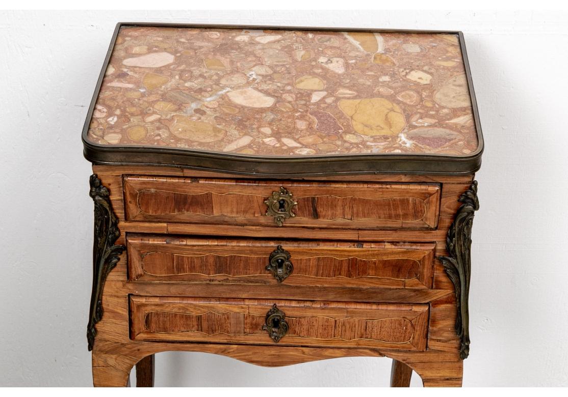 Christies label- London, 1994. A finely made French 18th c. writing table with ormolu mounts and beautiful variegated marble top. The three fine drawers with shaped front inlays and thin banded edges. Ormolu cartouche escutcheons (lacking a key).