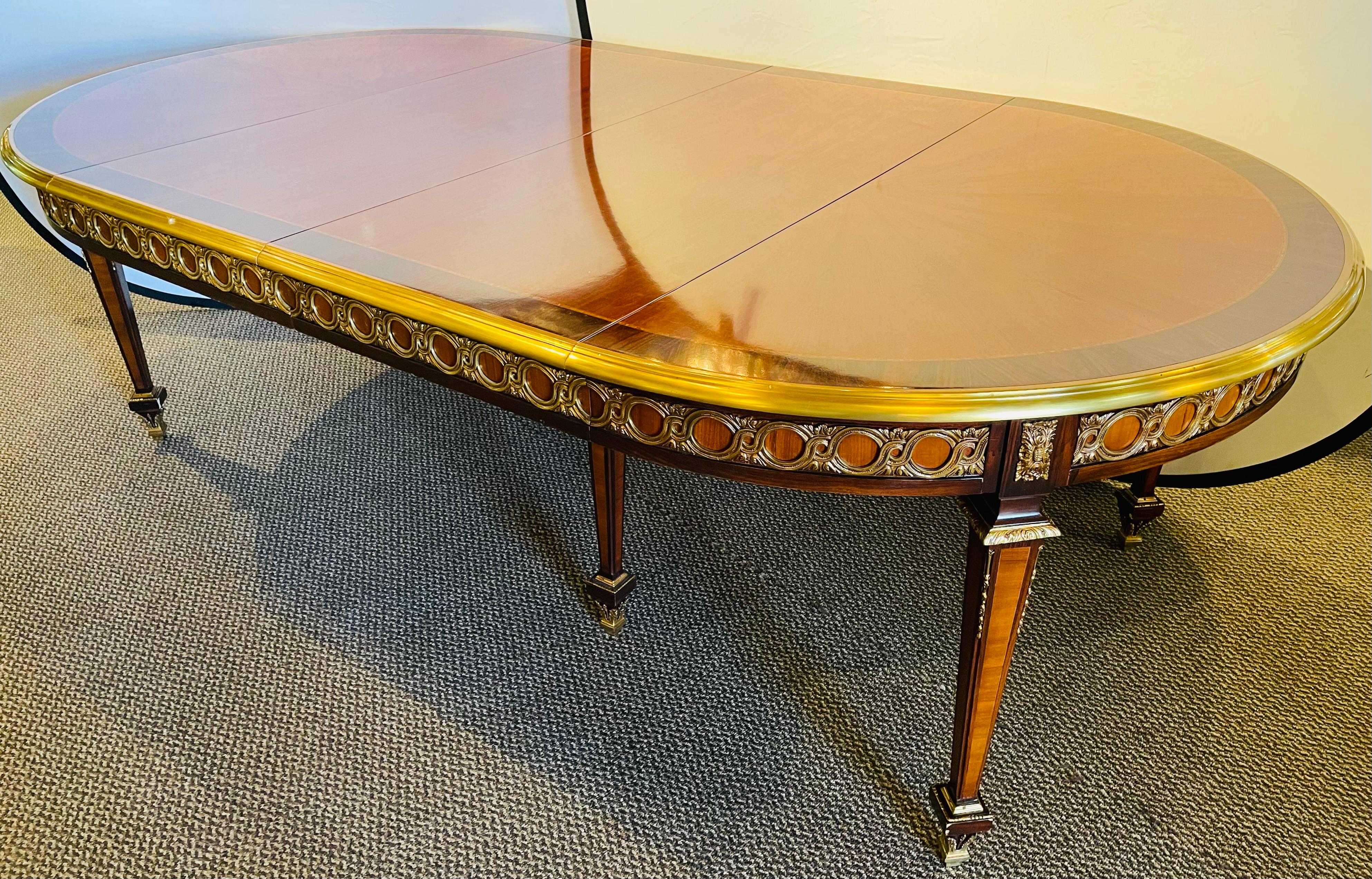 French Louis XV style dining table with three leaves. Ten feet long custom quality dining table having 3 leaves each measuring 22 inches. This fine heavy bronze mounted dining has two center leg supports and a finely detailed sunburst table top. The