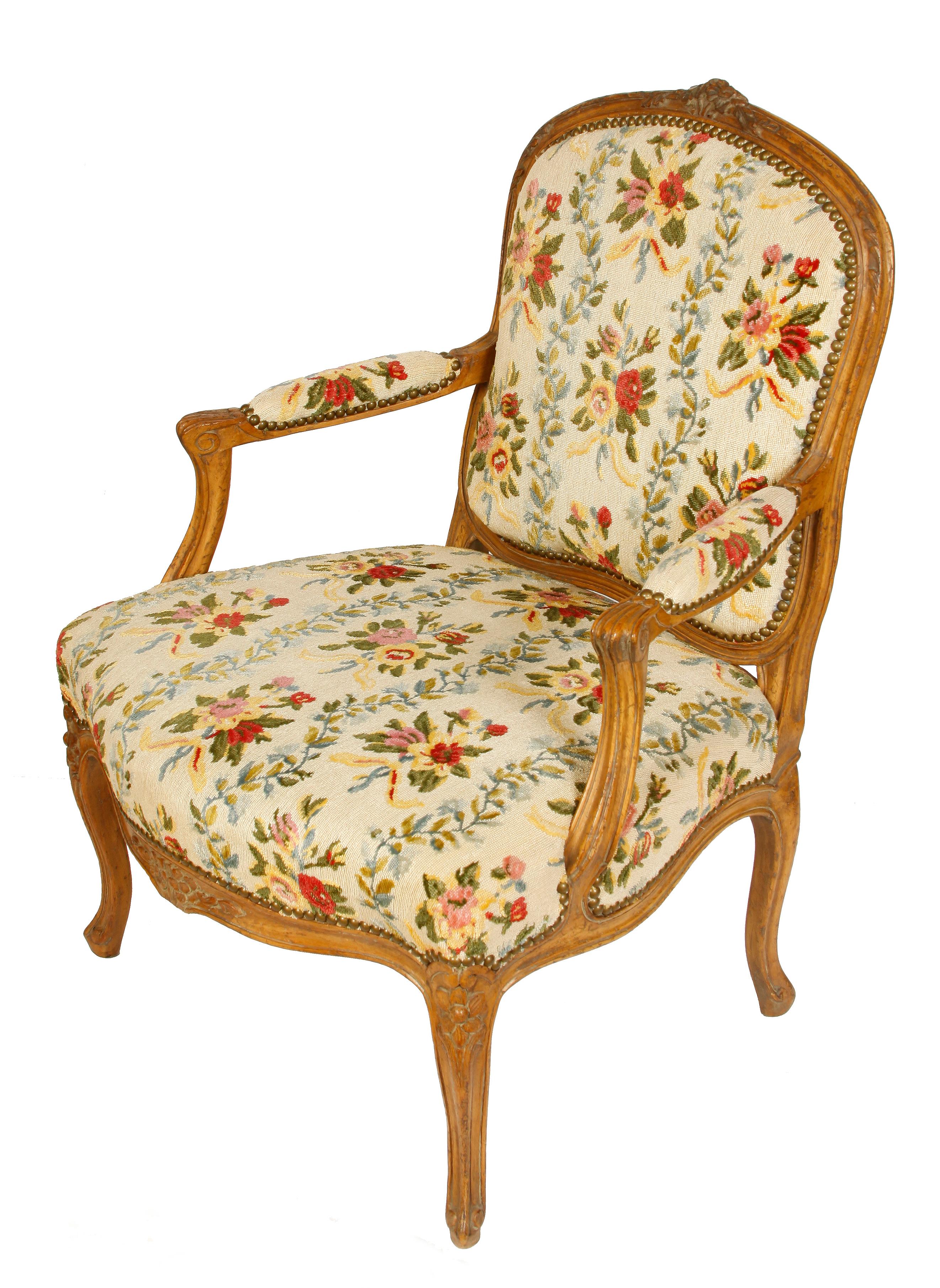French Louis XV style fauteuil in a lovely floral petit point pattern. Curved legs with carved floral details to back, apron and legs.