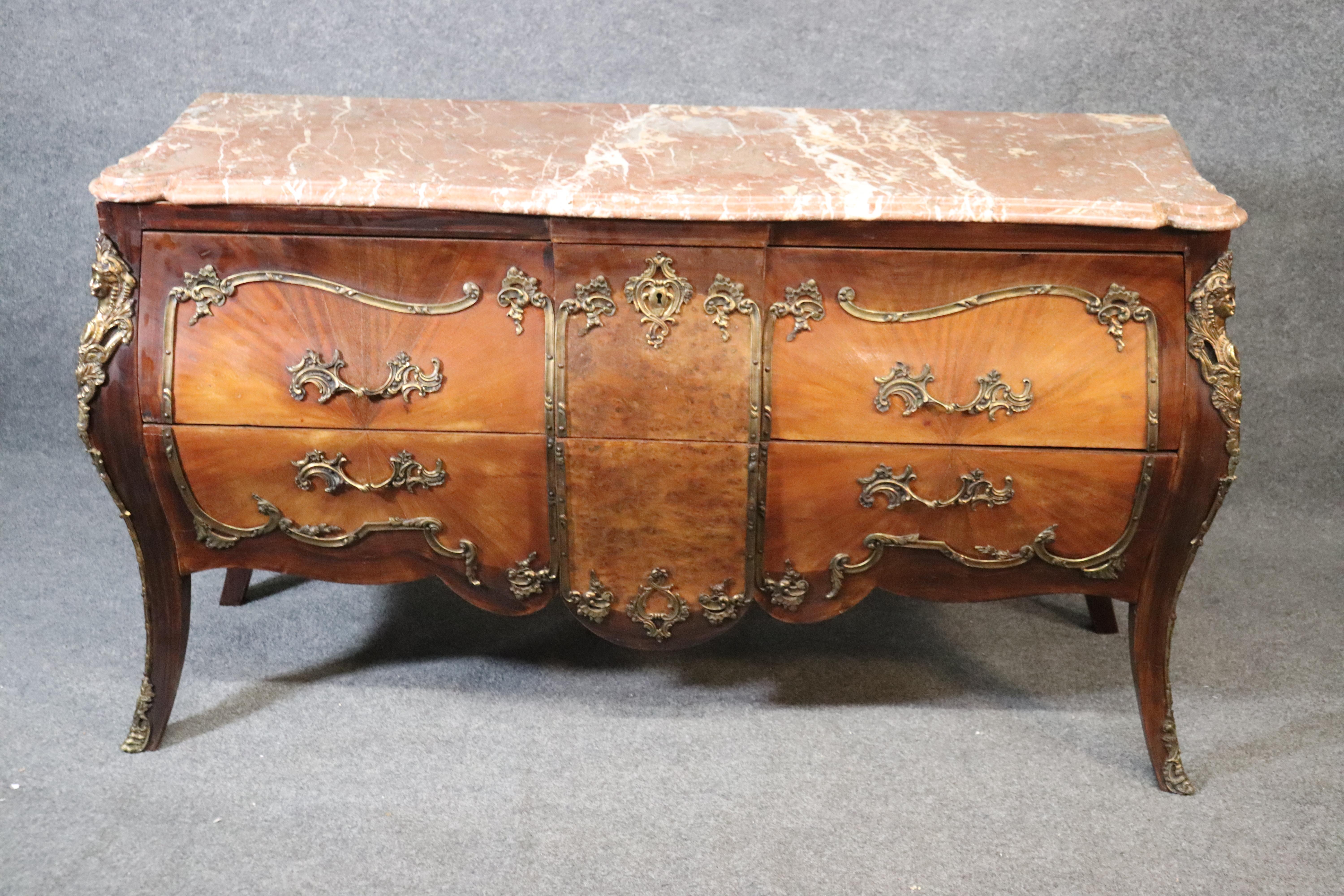 This is a beautiful French commode in the manner of Francois Linke of France. The commode features wonderful cast bronze maidens and ormolu troughout the case and a great slab of figured marble on top. The commode measures 60 wide x 22 deep x 34