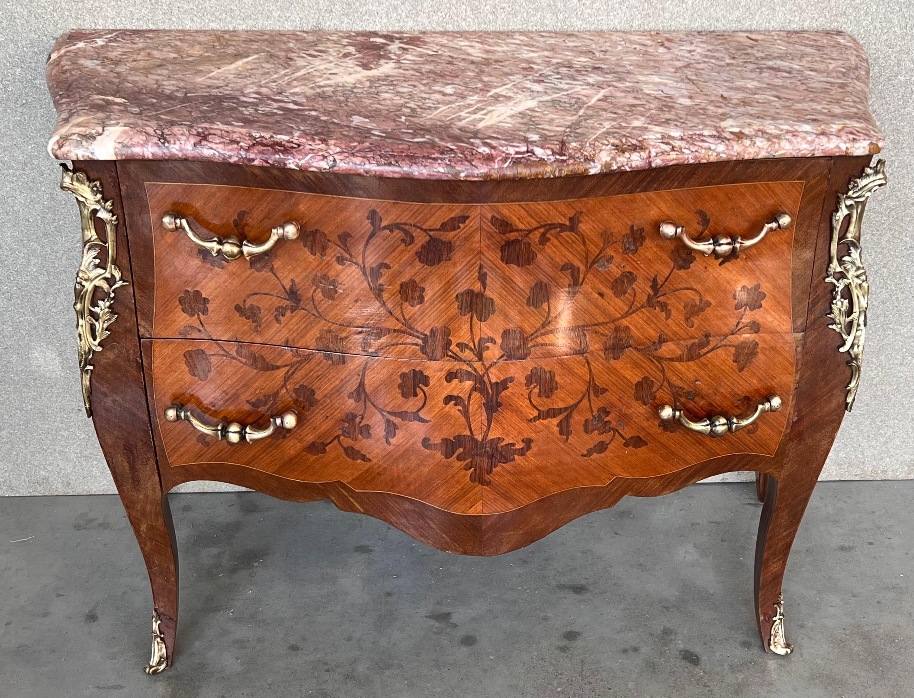 Commode française de style Louis XV en placage de bois de roi, le plateau de marbre façonné au-dessus d'une boîte à bombe avec des montures en bronze doré, fortement décorée d'incrustations de marqueterie avec deux tiroirs, sur de courts pieds