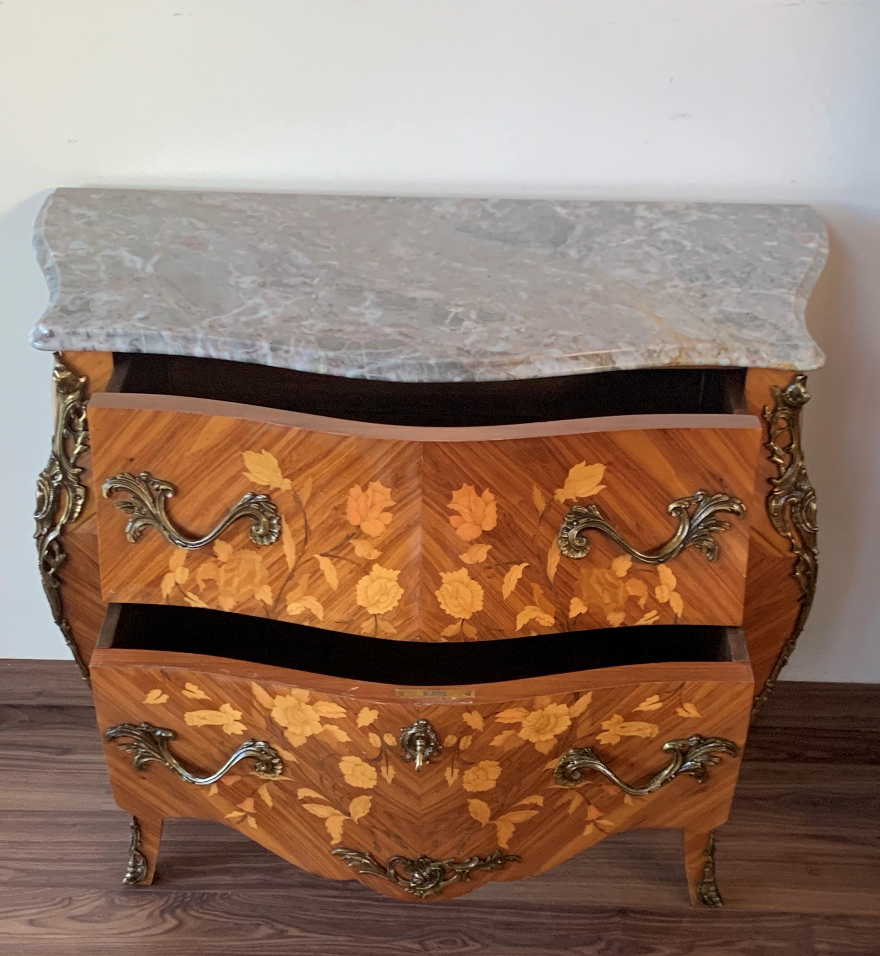 French Louis XV style kingwood veneer commode, the shaped marble top above a bombe case with ormolu bronze mounts, highly decorated throughout with marquetry inlay with two drawers, on short cabriole legs.


  