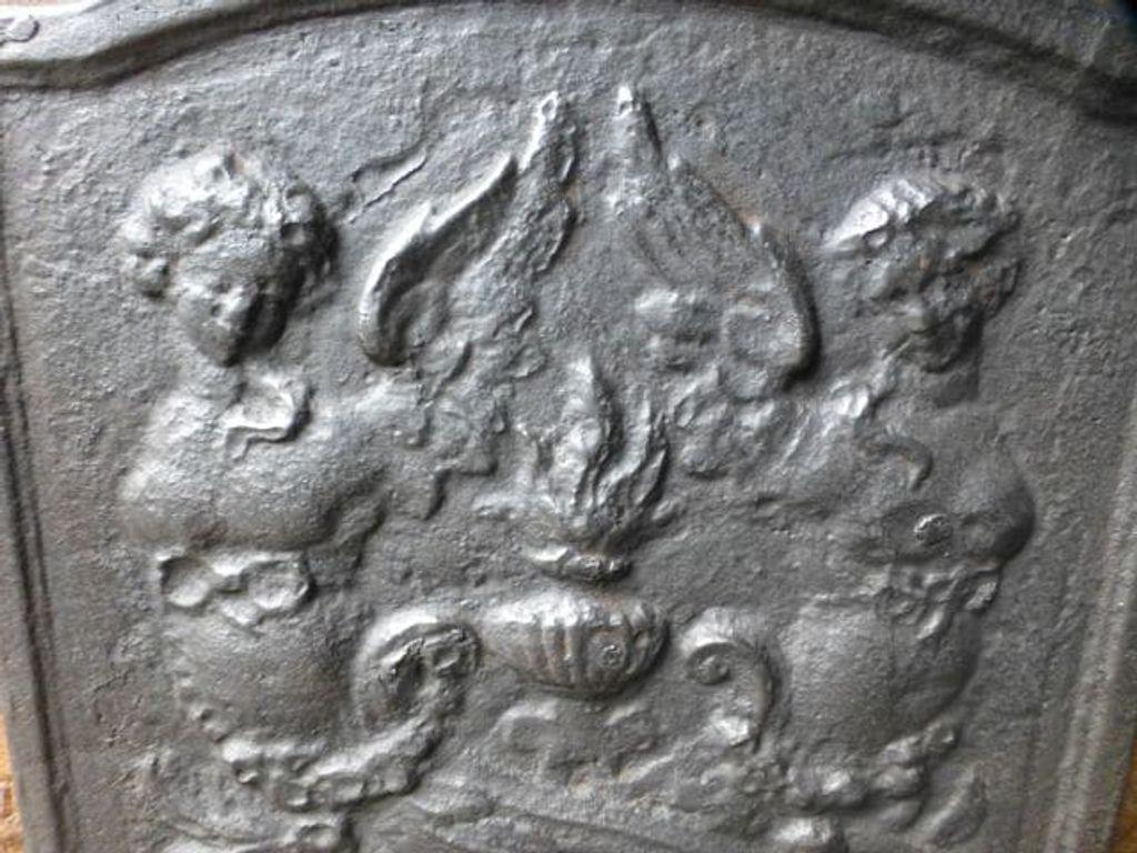Plaque de cheminée du 20e siècle de style Louis XV avec un pot de feu et deux anges.

La plaque de cheminée est en fonte et présente une patine noire/étain. La plaque de cheminée est en bon état et ne présente pas de fissures.
