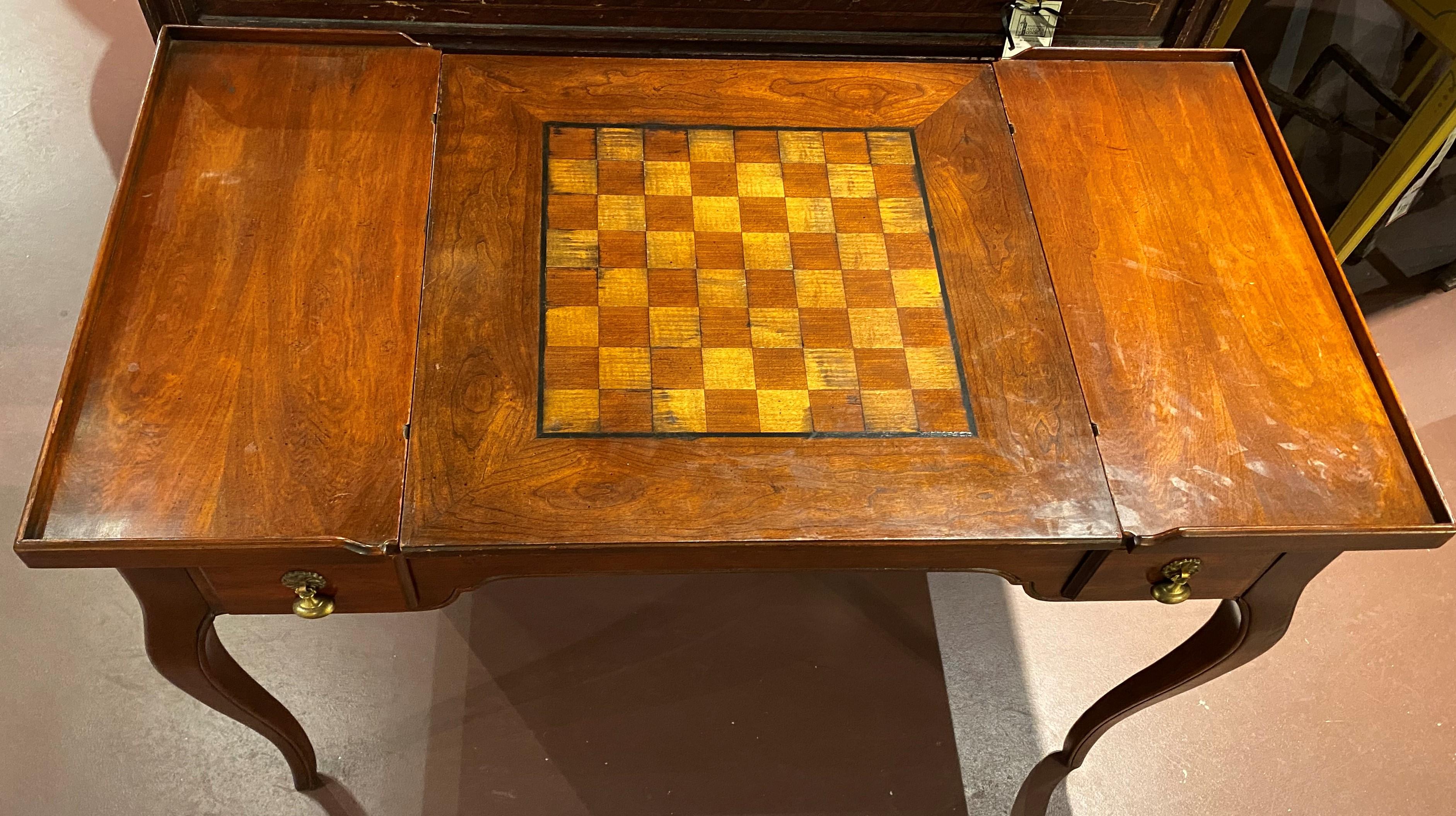 A fine example of a fruitwood gaming table in the Louis XV style, with removable and reversible satinwood inlaid chessboard center top, which opens to a backgammon compartment below. The table has two fitted drawers on each side with decorative