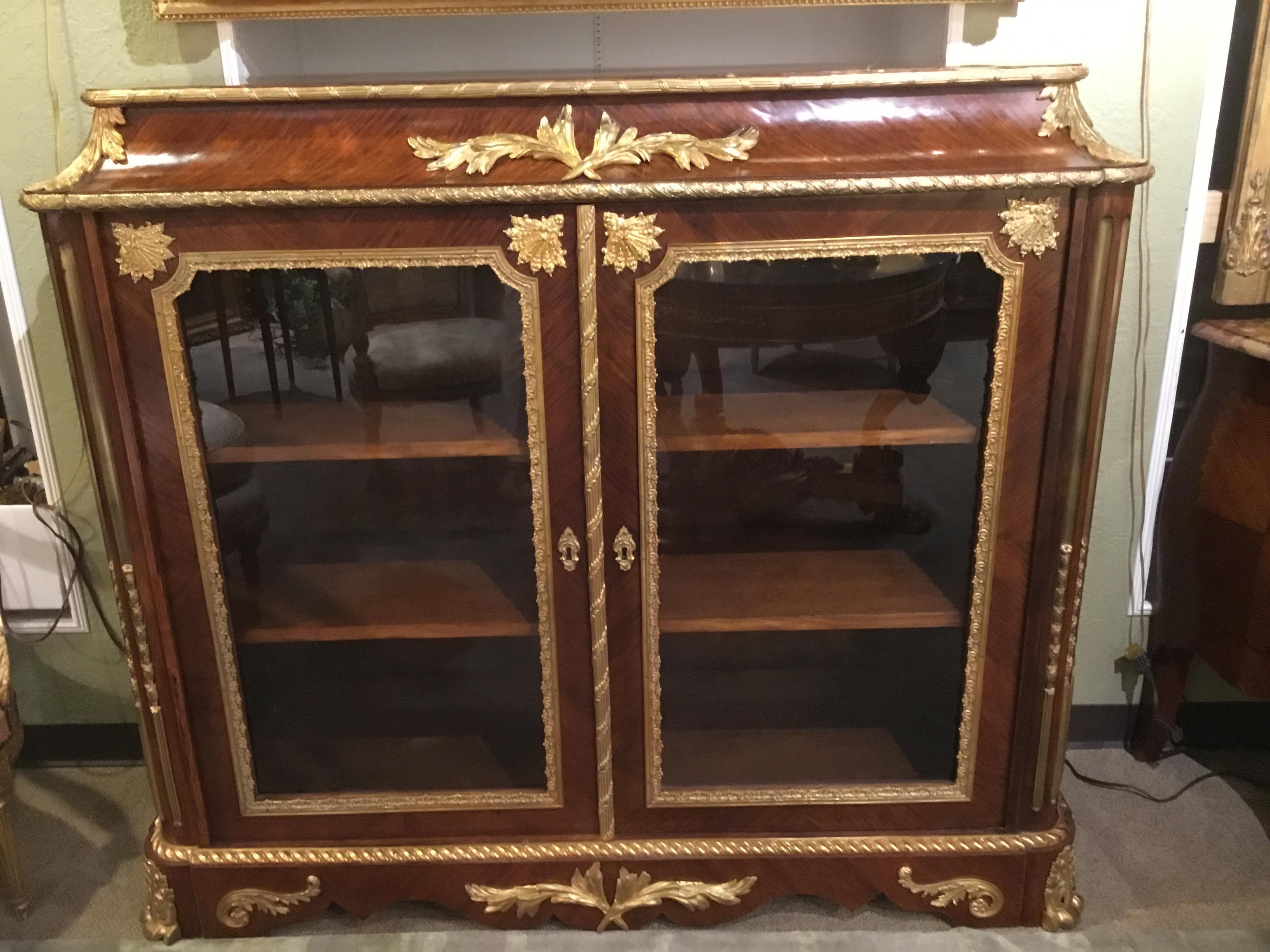 Very fine French vitrine/bibiotheque, late 19th century with fine walnut veneers. Gilt bronze mounts
Enhance the beauty of this piece. Serpentine upper portion of the cabinet adds a sculptured look
To the cabinet. Two glazed doors open to the
