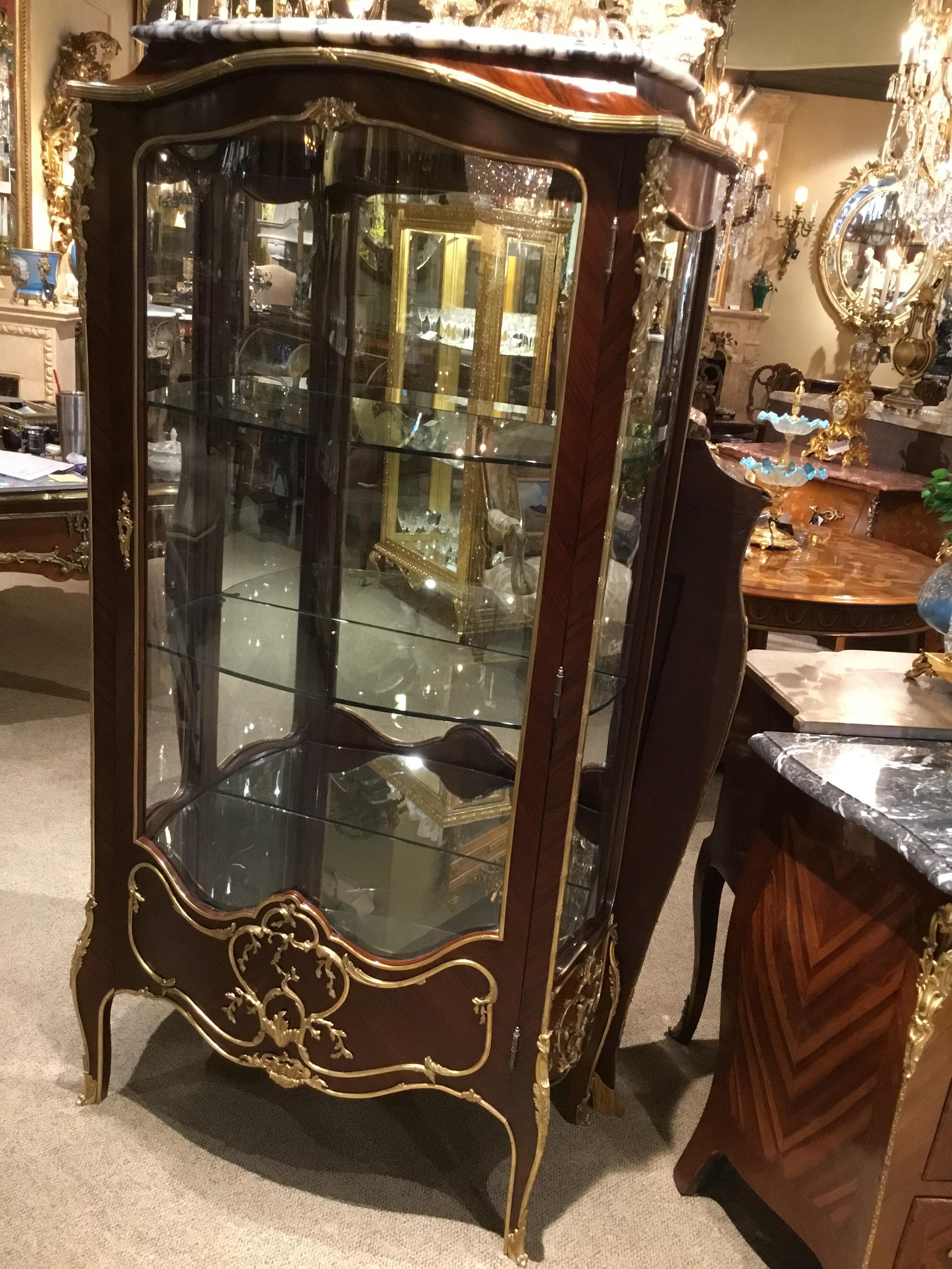 Exceptional quality vitrine cabinet which works well as a display, having glass sides and a curved
glass front panel which domes upward at the center. It has a mirrored back and mirror on the bottom
shelf. It has two glass shelves. The cabinet is