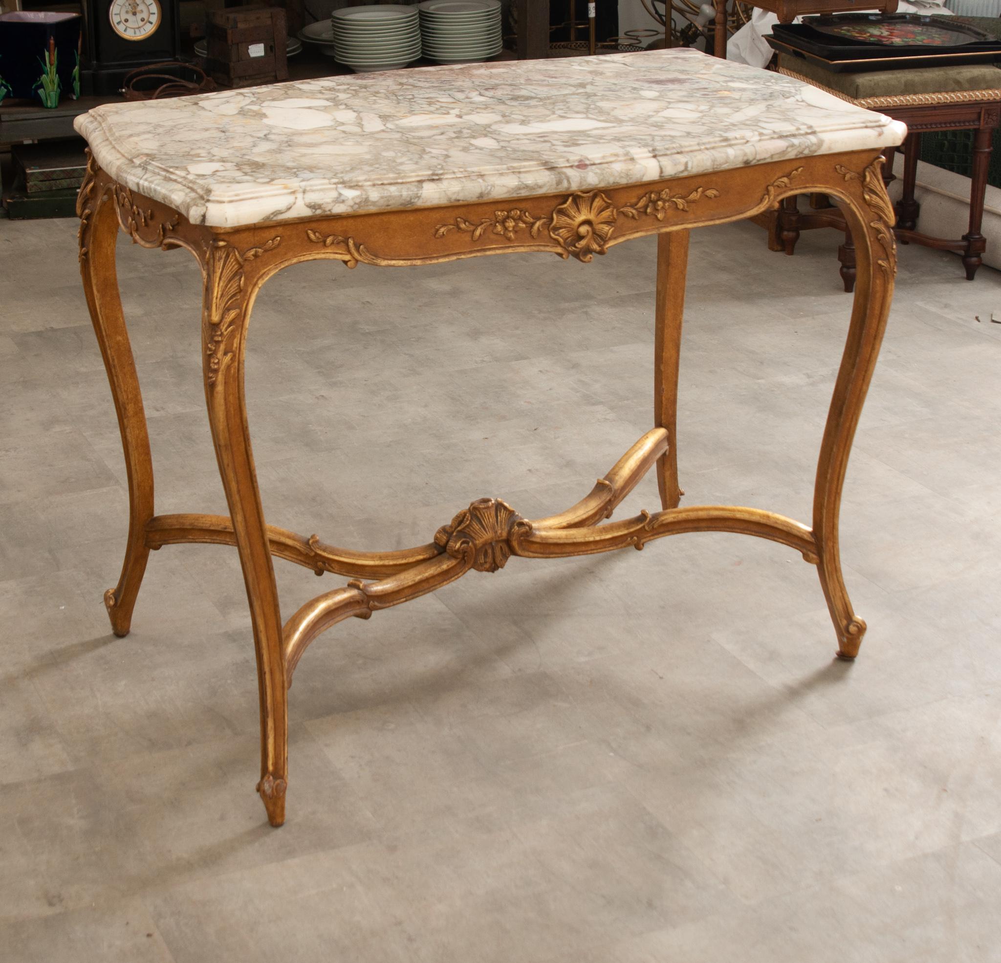 Its original shaped and beveled marble top has wonderful coloring throughout and is removable for transport. The painted and gilt base has a scalloped and carved apron featuring floral and shell motifs and flanked by scrolls and more foliage on the