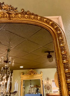 French Louis XV Style gilt mirror with foliate crest, 20 th c.