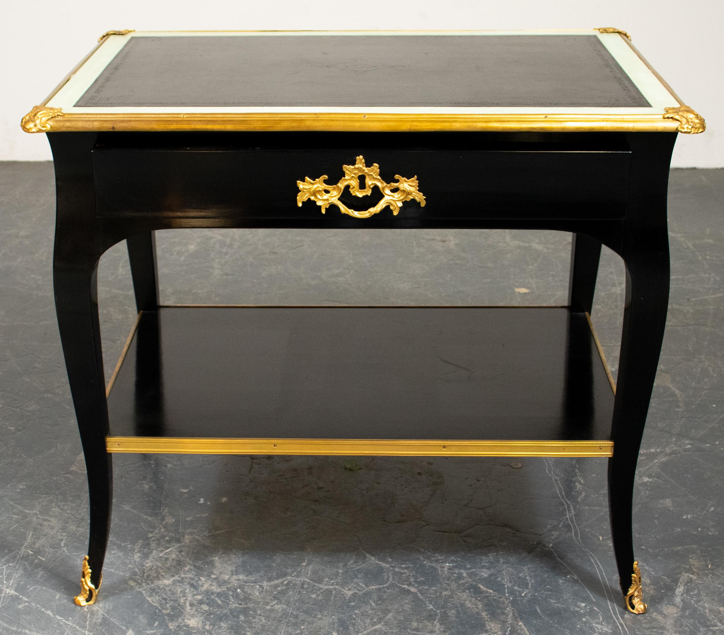 Louis XV style ebonized two-tier tea table, 20th century, the top and shelf with gilt metal banding, with single drawer, the cabriole legs terminating on scrolling gilt metal sabots. Measures: 28” H x 33” W x 23” D.