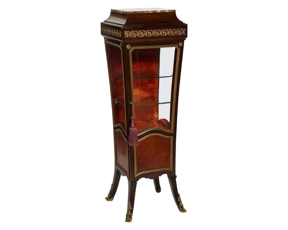 A French Louis XV Style gilt metal mounted Kingwood edestal vitrine cabinet, circa 1880.

Very nice quality, very rare, unusual form. Pedestal and vitrine with glass shelves and red velvet lined on the inside, with original rouge marble and