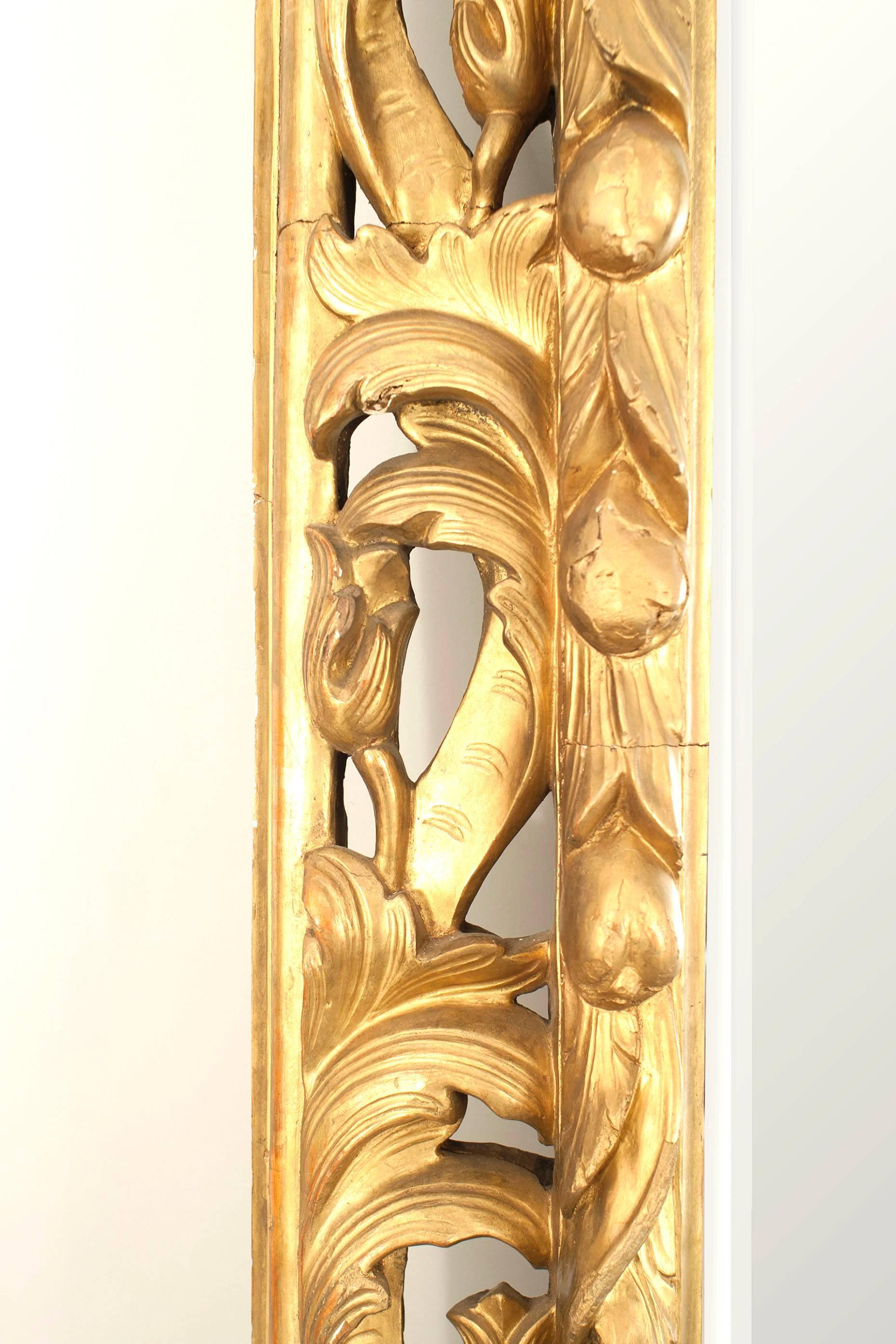 Miroir mural de style Louis XV (19e siècle) en bois doré sculpté, à décor de feuilles d'acanthe et de boutons floraux et miroir biseauté. (étiquettes en métal au dos estampillées CHENUE)
