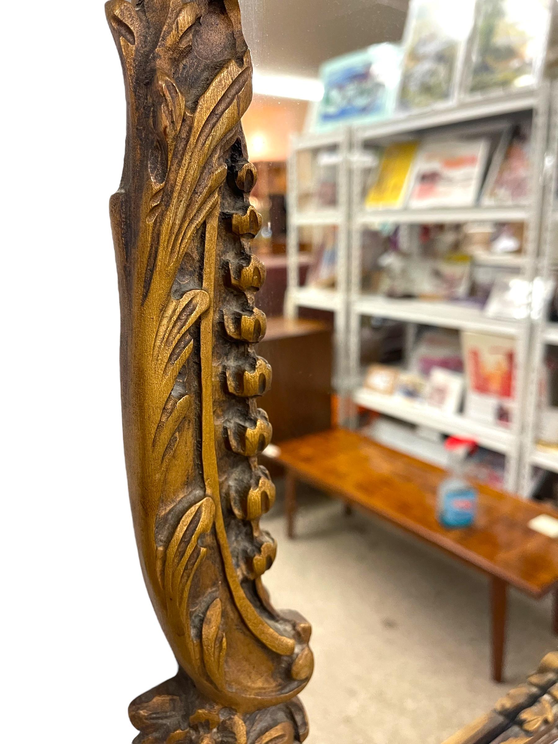 Miroir mural en bois doré de style Louis XV avec écusson en coquillage et détails floraux. en vente 1