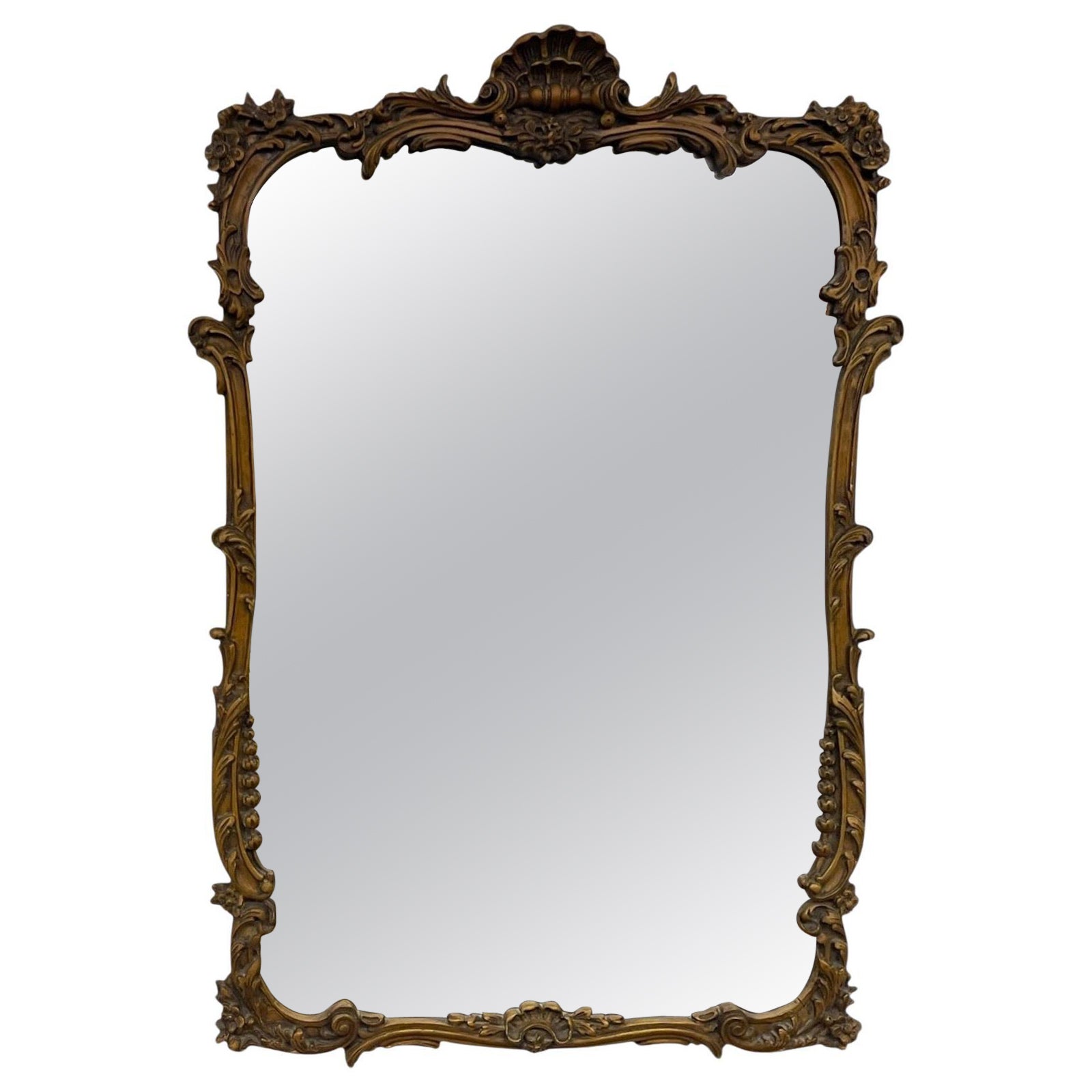 Miroir mural en bois doré de style Louis XV avec écusson en coquillage et détails floraux. en vente