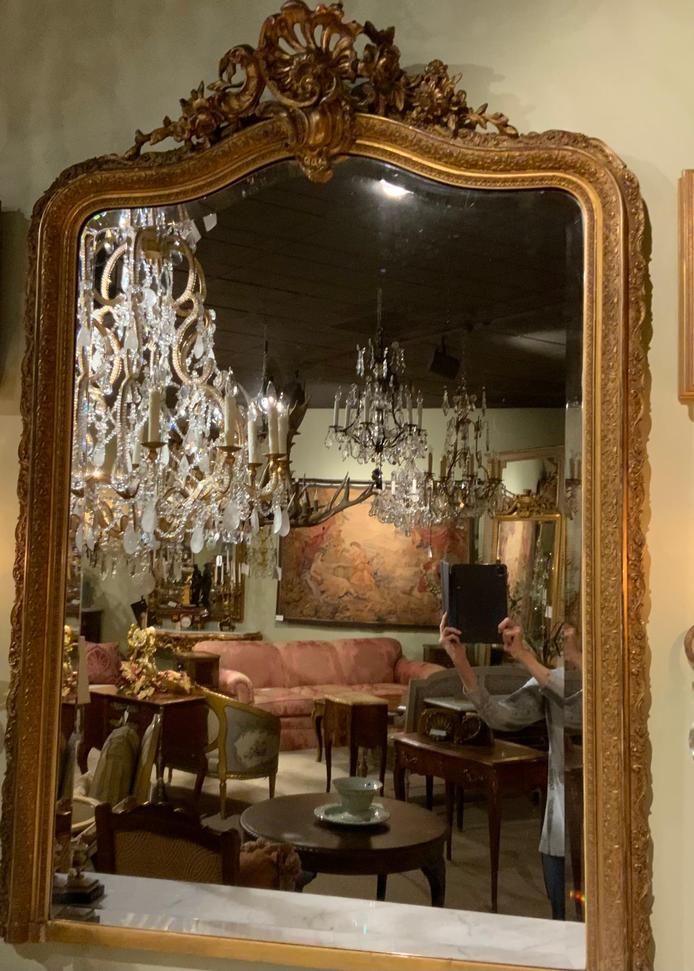 The giltwood has the original antique patina that makes this piece
Exceptional. The cartouche at the top is expertly carved with fine detail.
The outer framework also has finely carved detail scroll work around
The entire perimeter. It has a wide