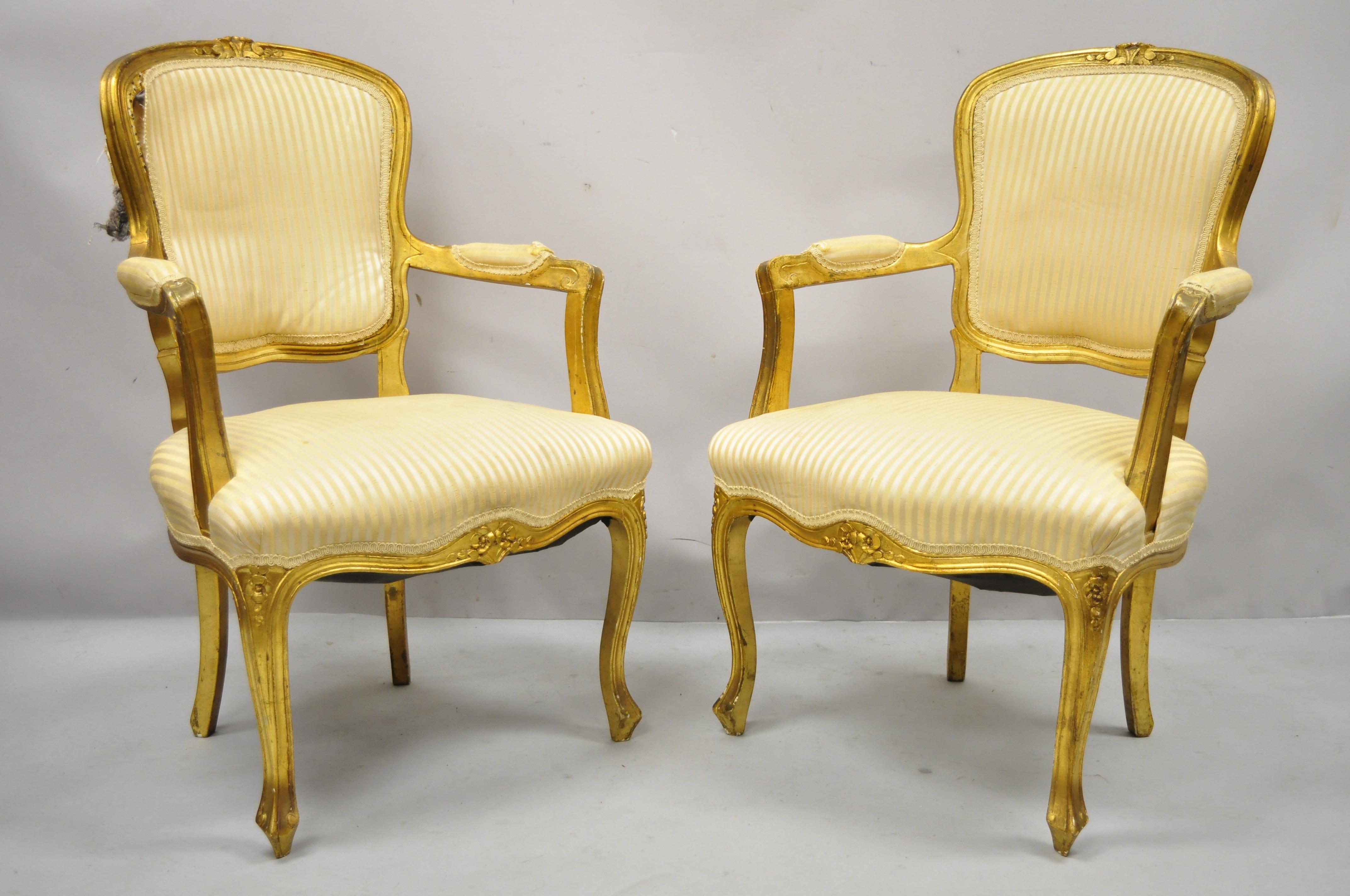 Französische Louis XV Stil Gold vergoldet Fauteuil Arm Stühle zu renovieren DIY-Projekt - ein Paar. Der Artikel zeichnet sich durch eine Massivholzkonstruktion, gepolsterte Armlehnen, goldfarbenes Distressed-Finish, Cabriole-Beine, großen Stil und