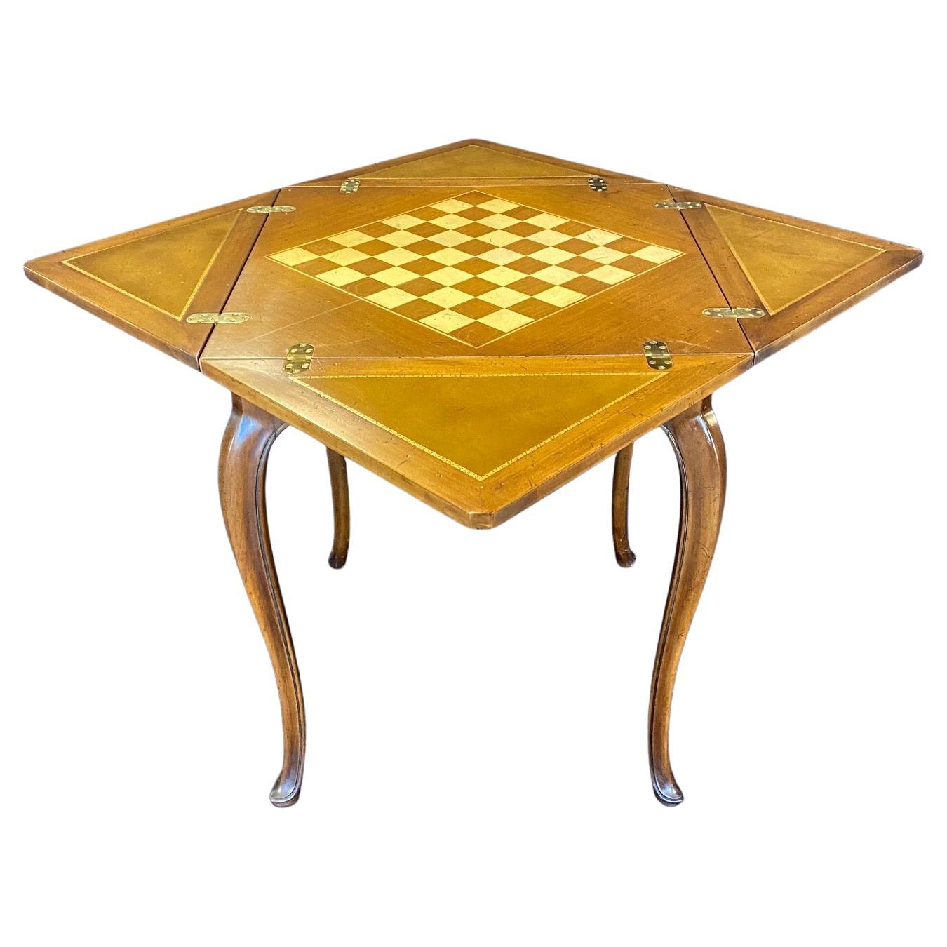 A Classic French Louis XV style handkerchief card table that cleverly transforms from a narrower side table into a square gaming surface with embossed leather leaves, all supported by slender and elegant cabriole legs. All moving parts function
