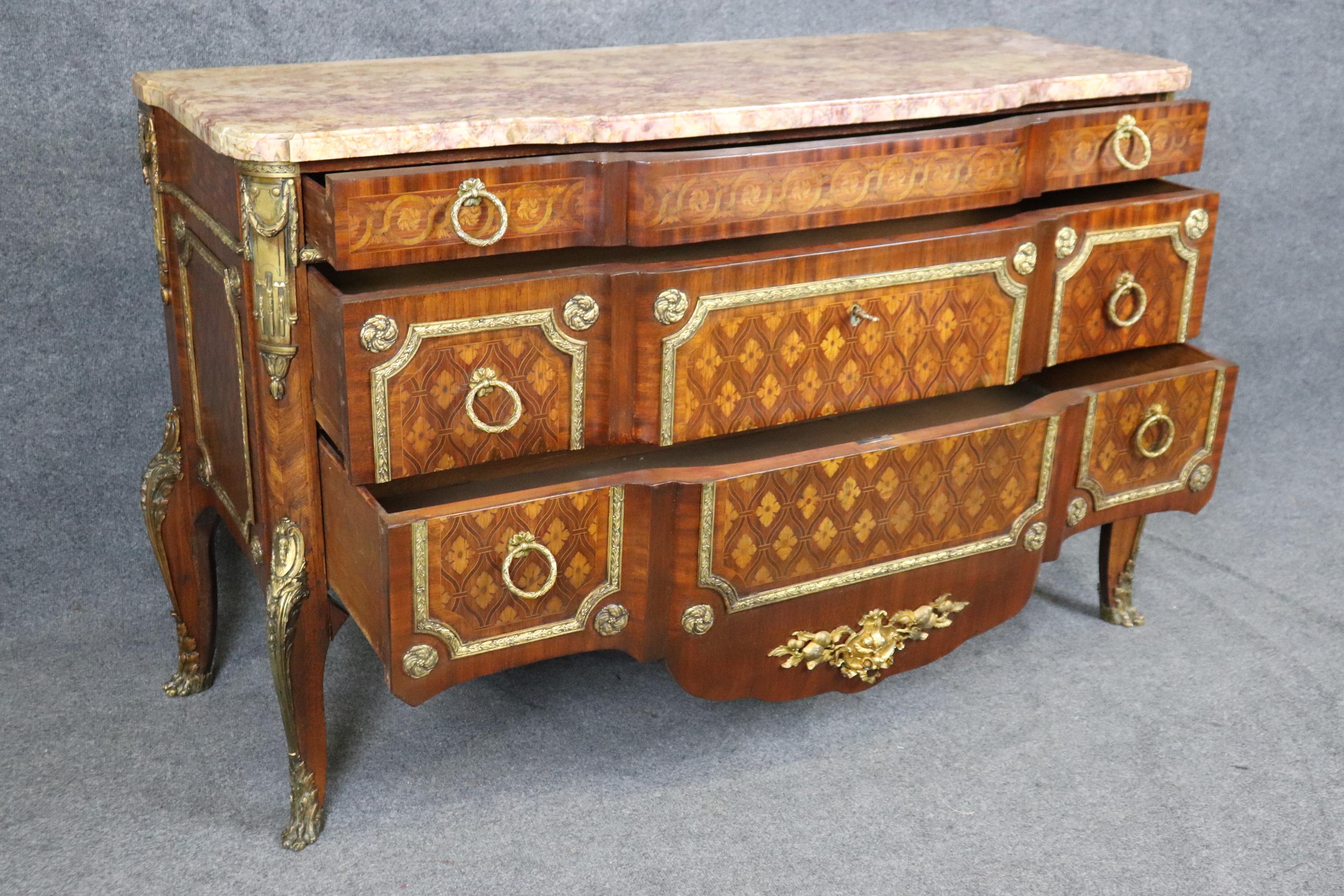 Si tratta di una commode superbamente realizzata nello stile di Roger Vandercruse Lacroix. Il comodino presenta un prezioso intarsio di legni misti, tra cui il legno di raso, il noce e il kingwood. Il disegno, riccamente ornato con il più raffinato
