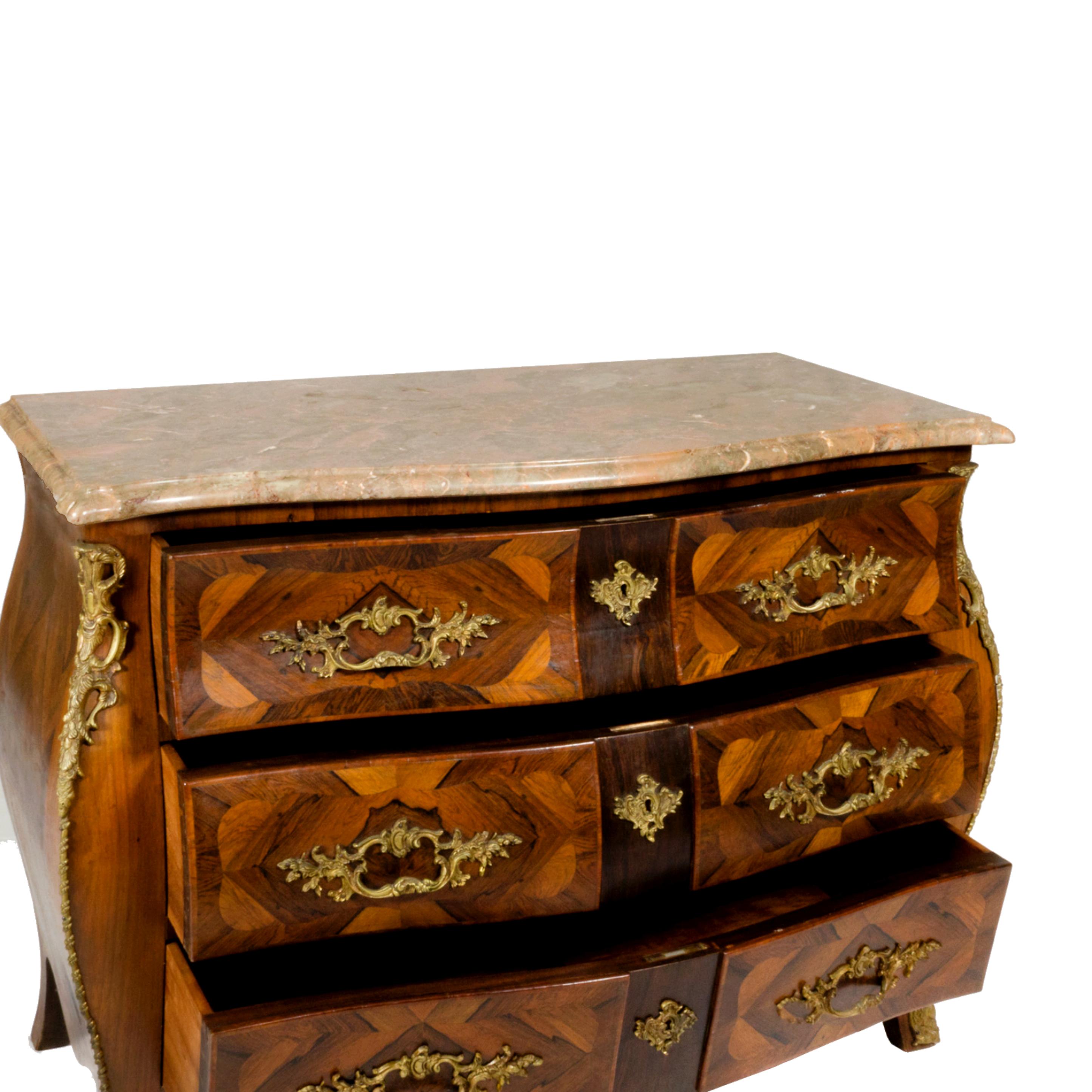 This beautiful chest is designed in the elegant French Louis XV style, featuring a stunning marble top with intricate marquetry inlay and bronze hardware. The top is gracefully shaped with beveled edges, and the chest has three spacious drawers that