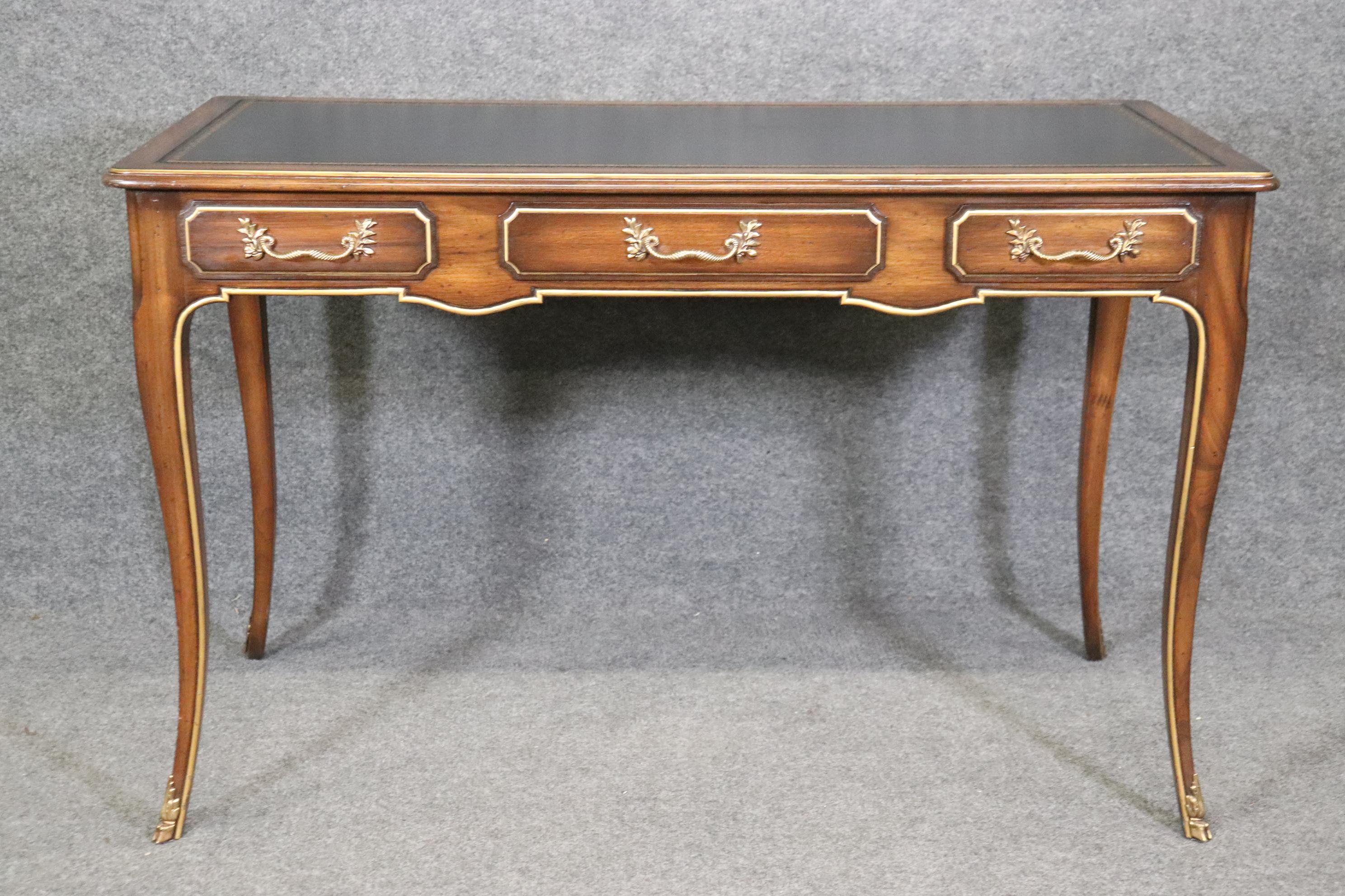 Dimensions- H: 30in W: 49in D: 24 1/2in 
This French Louis XV Style Leather Top Desk In The Manner of Baker is a lovely piece of furniture that is a great example of quality furniture in the late 20th Century. If you look at the photos provided you