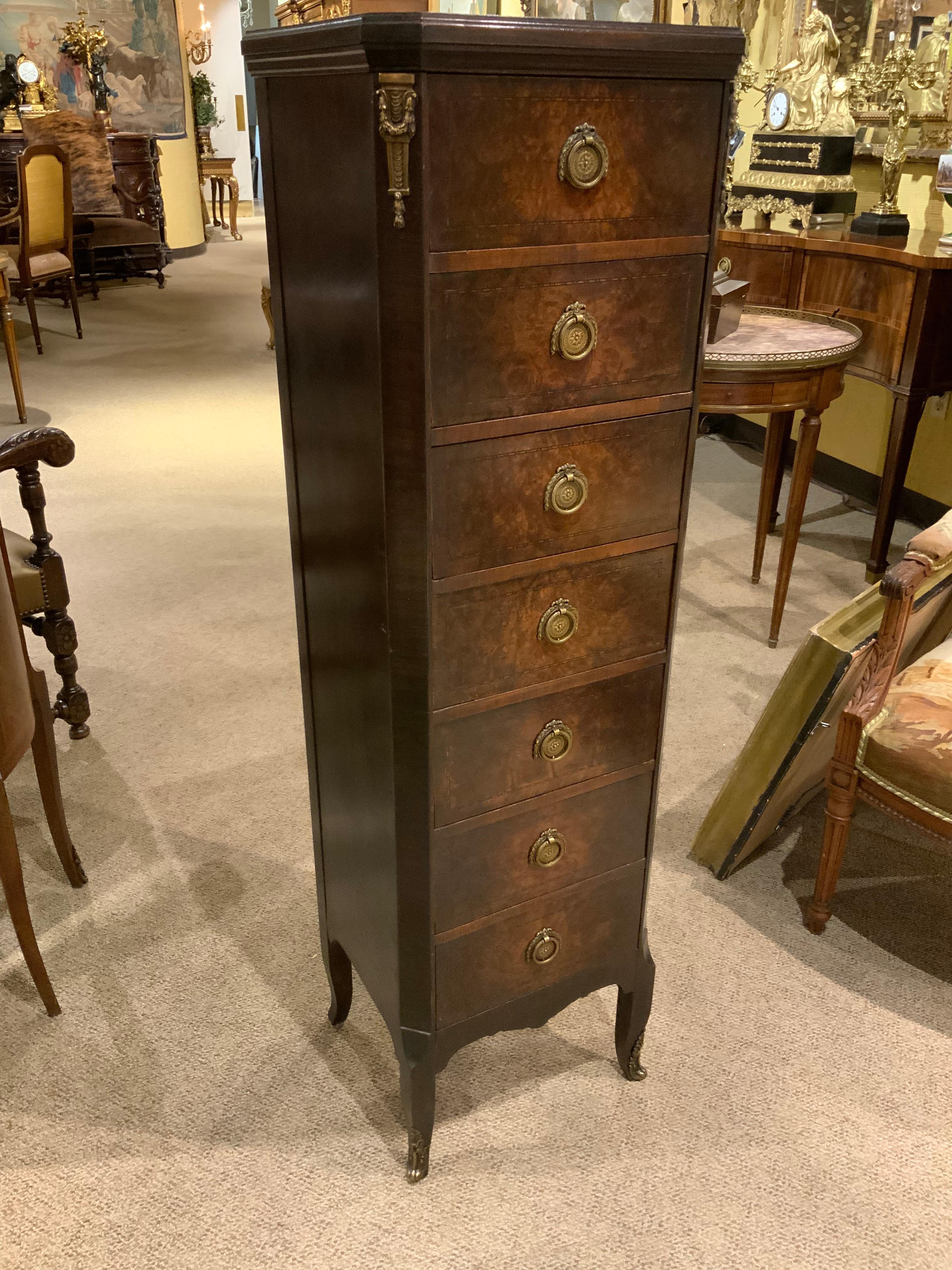 Lovely petite slender chest in burled walnut with multiple drawers for great storage.
Gilt bronze mounts with sabots at the feet.