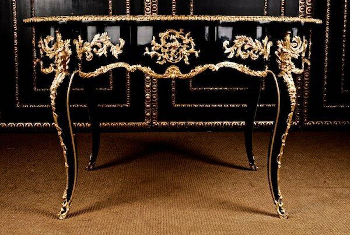Majestic French Louis XV style saloon table.

Black polished veneer on solid pine. Exceptionally finely engraved decorative broken rocailles inlaid with acanthus and blooming details, on two future-oriented imposing bearded devil masks on curved