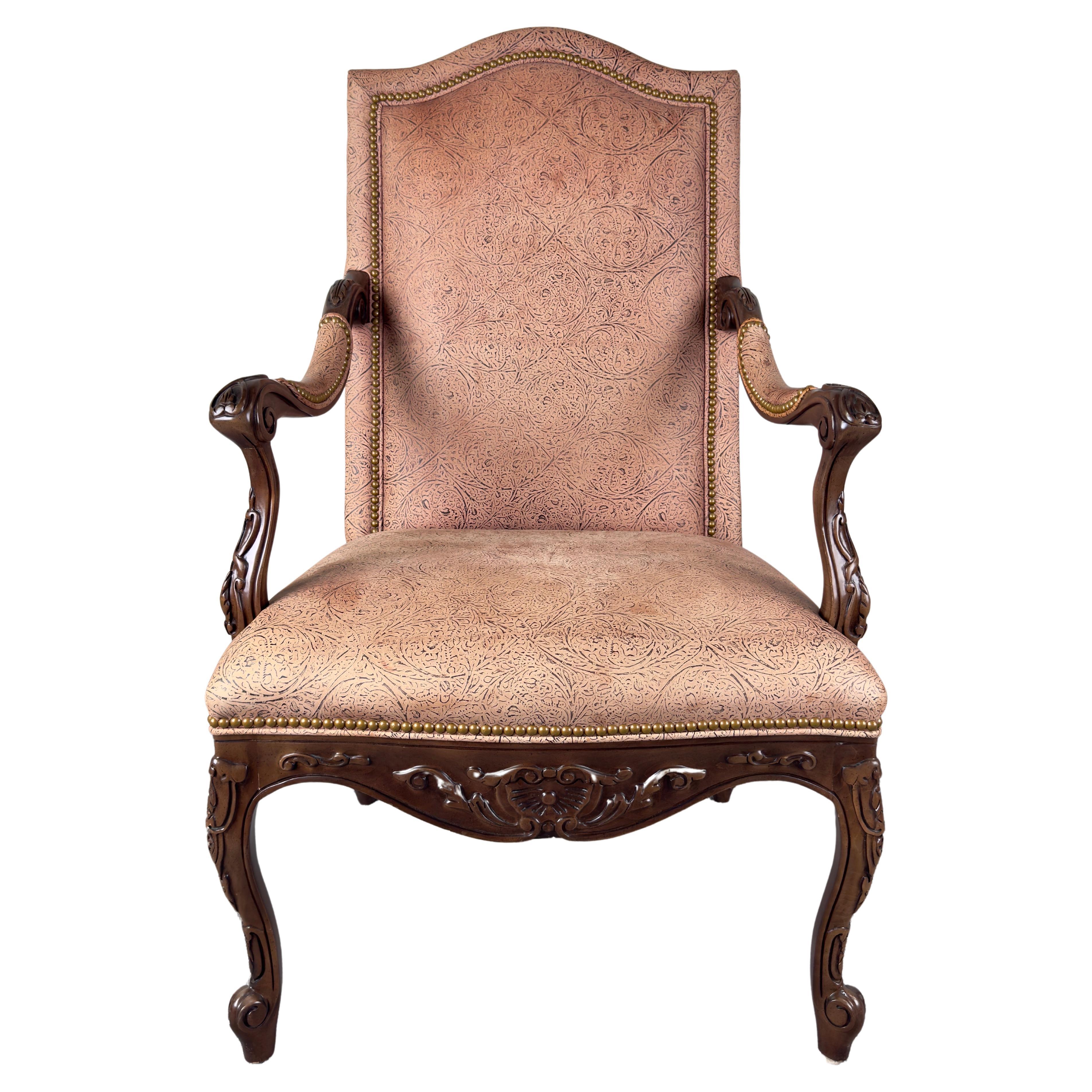 An elegant French Louis XV style armchair or accent chair. The mahogany frame is meticulously carved with intricate motifs. The cabriole legs, adorned with delicate scrollwork, gracefully elevate the piece, while the armrests curve with an air of
