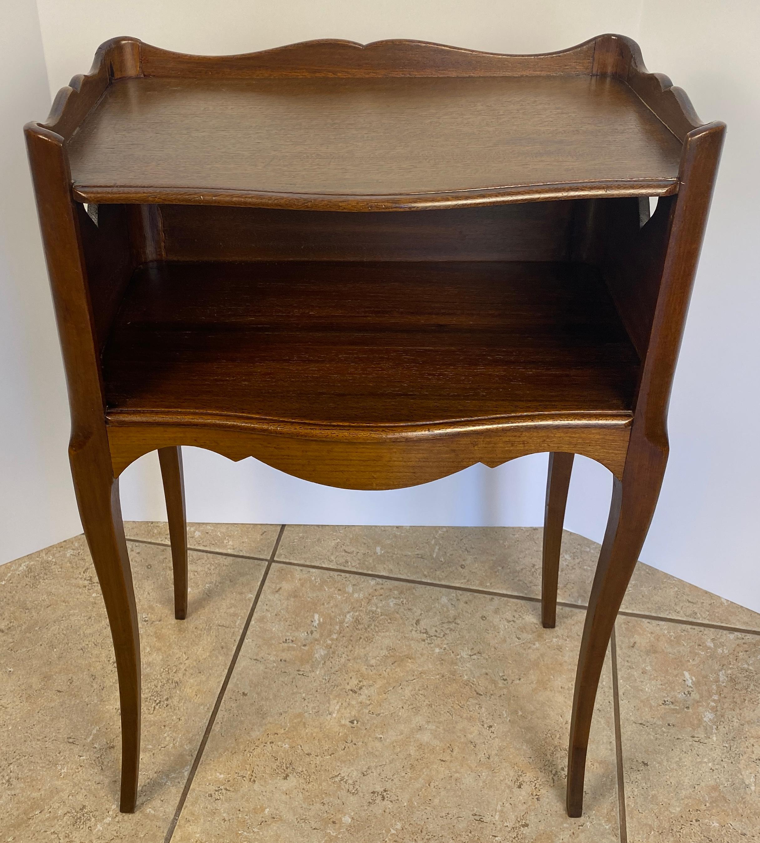 A Louis XV style country French side table or nightstand made of solid mahogany, with open niche and pierced cut-out heart shapes on the sides. Scalloped apron and gallery surrounding the top. One drawer. 

Very good quality table with curved