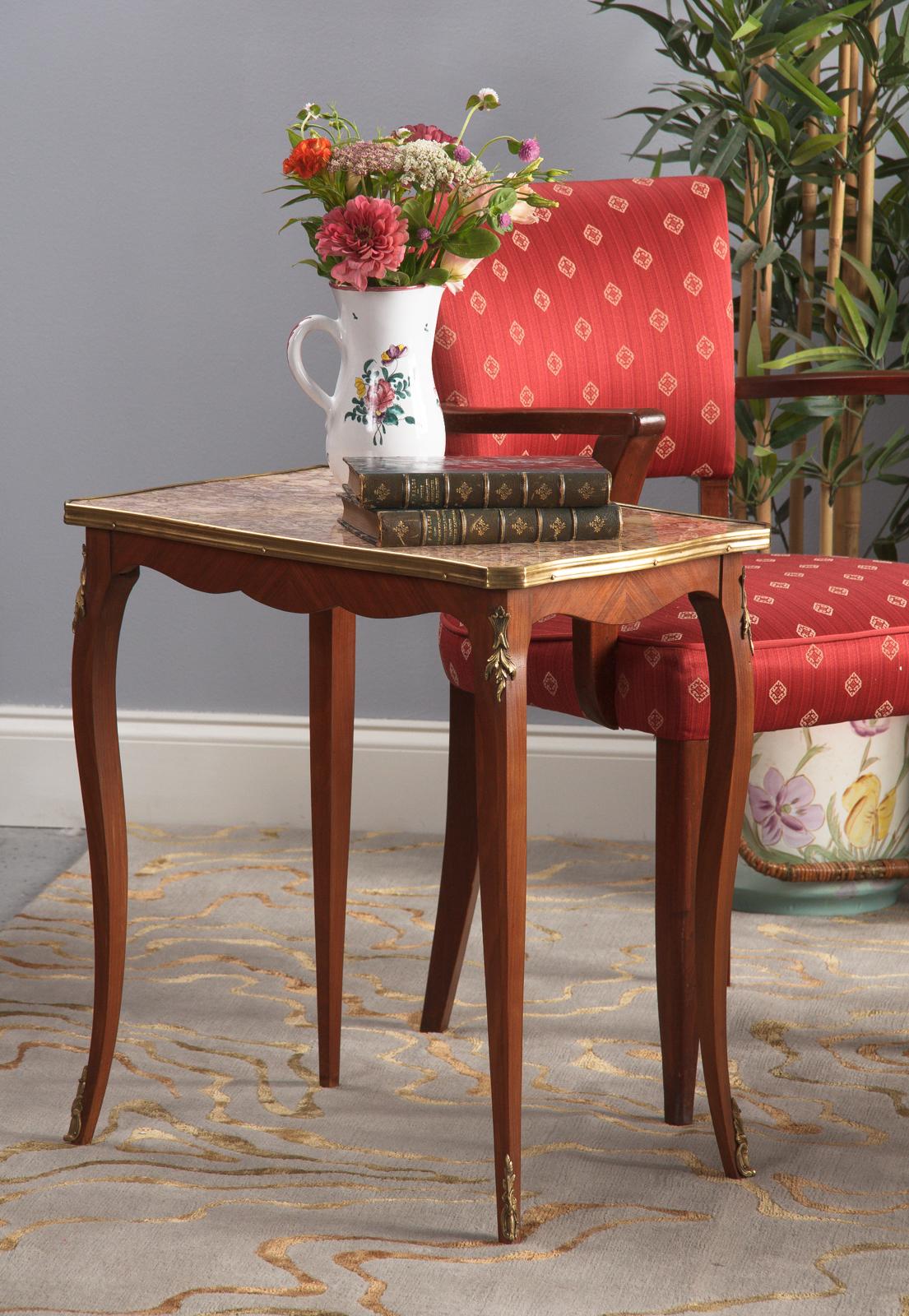 A dainty vintage Louis XV style side table with Breche marble-top, French, circa 1940. Cherrywood veneer base with cream and blush Breche marble-top trimmed in brass. Curved, attenuated legs are tipped in scrolled acanthus brass sabots with matching