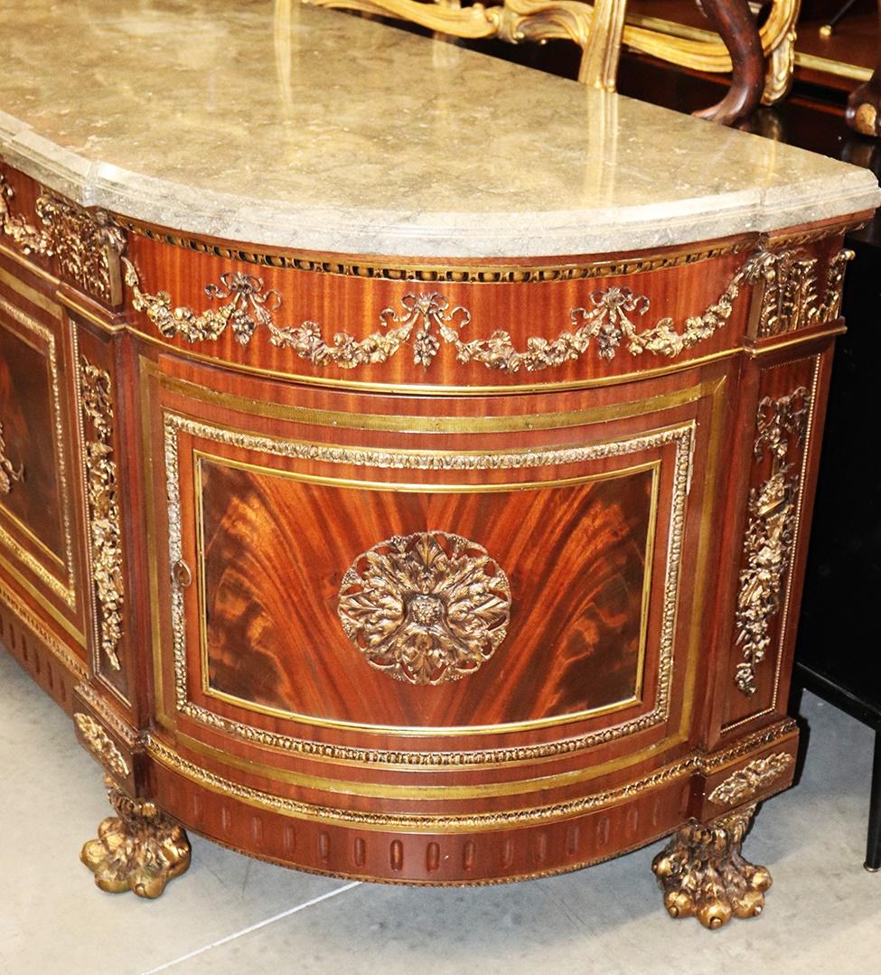 French Louis XV style bronze mounted marble top flame mahogany side board with 4 drawers and 2 doors each containing 1 shelf.