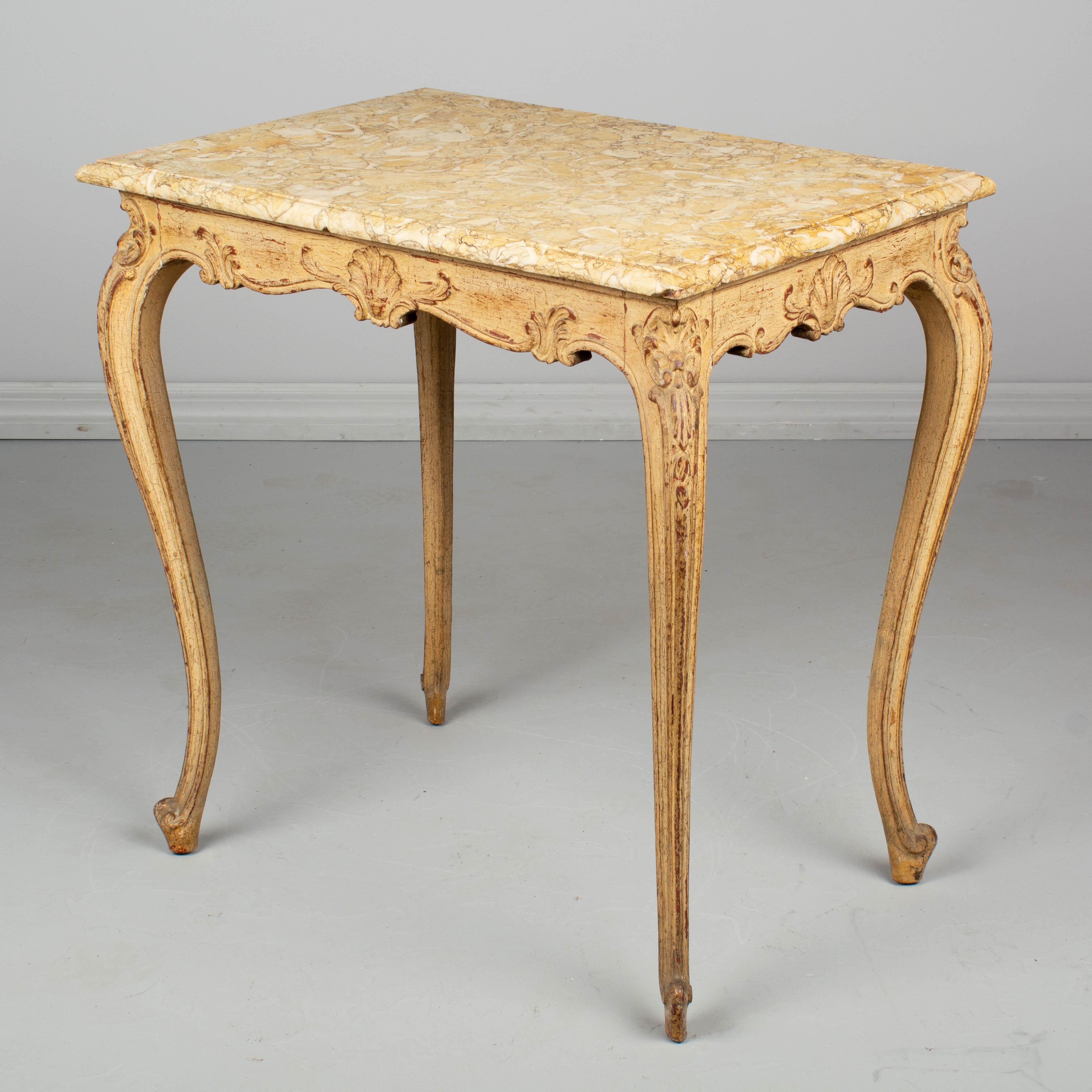A French Louis XV style side table with painted patina and original marble top. Small chip to corner of marble and a small repair. Circa 1920-1930.  27.5”H x 18.75”D x 26.5”H
Contact us for a competitive shipping quotation. Please refer to photos