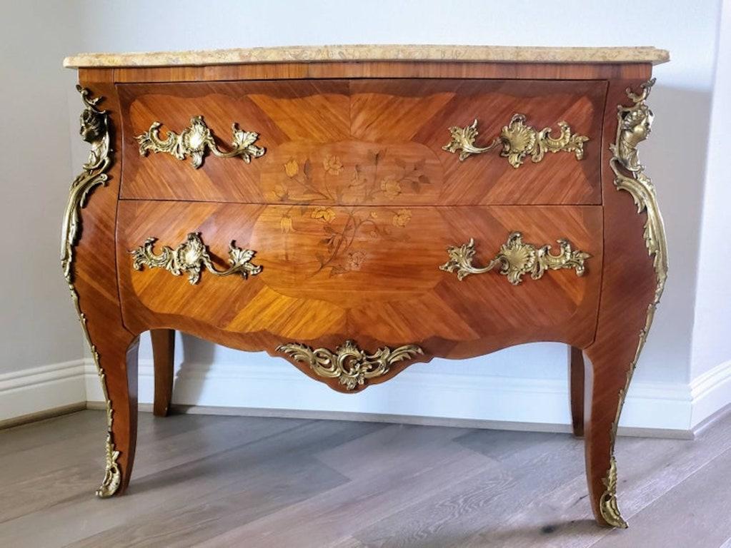 An exquisite French bombe form chest from the early 20th century. Handcrafted in Louis XV taste, having a shaped marble top with molded edge, exceptionally executed marquetry inlaid case, book-matched veneers, cross-banded inlay, the nicely curved