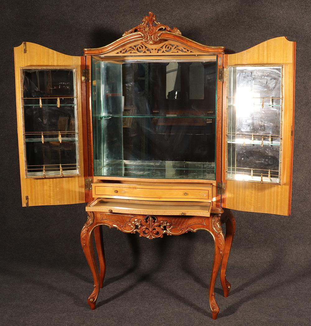 This is a superb carved French satinwood and gilt wood martini bar. Look inside and notice the incredible mirrored shelves and interior. The piece is absolutely perfect for setting up your favorite drinks and glasses for entertaining you valued