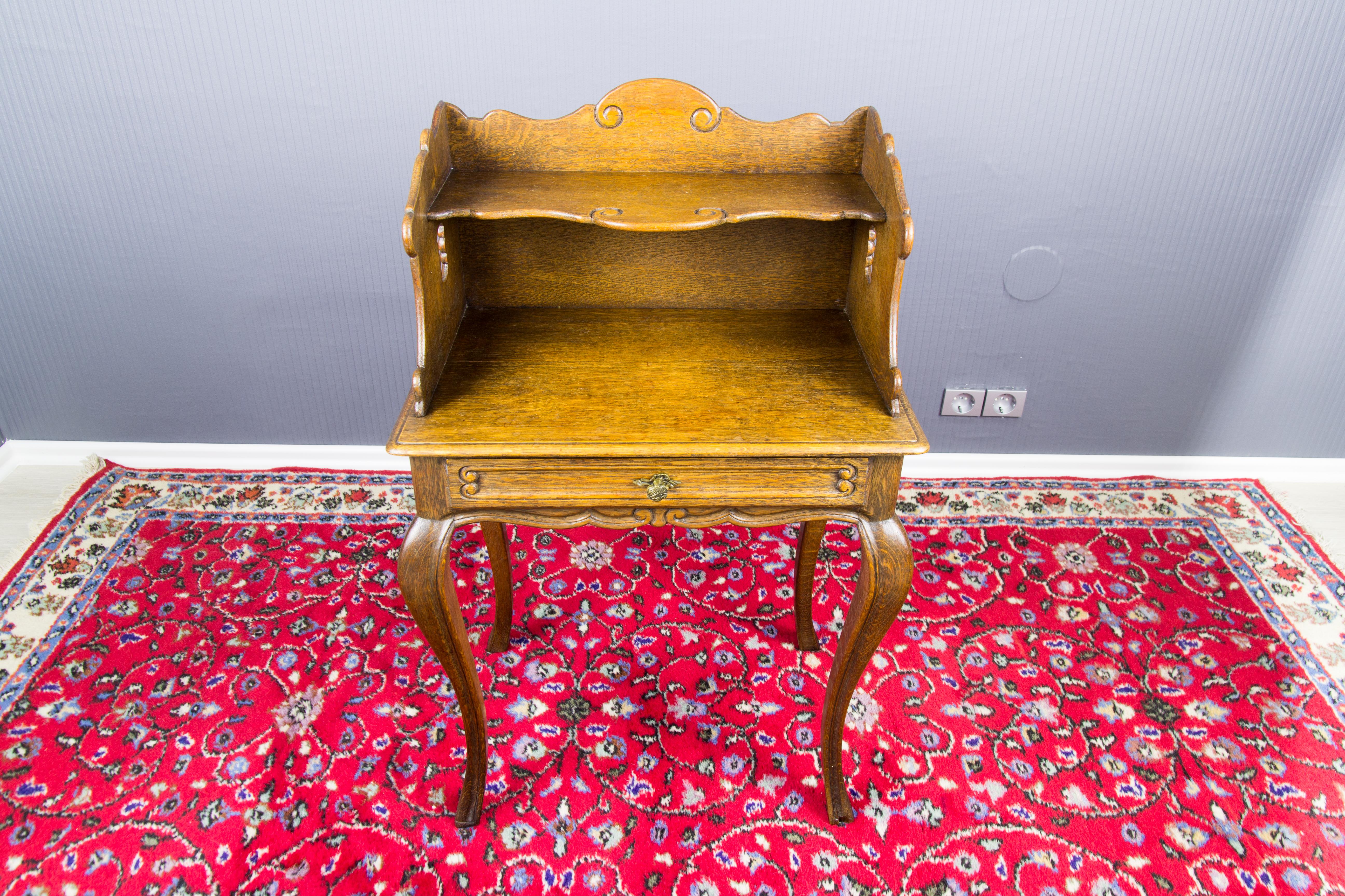 Charming French Louis XV style nightstand or side table made of oak. The scalloped top shelf above open recess with a single drawer. Raised on graceful cabriole legs.
Dimensions: height 78 cm / 30.7 in; width 50 cm / 19.68; depth 34 cm / 13.38 in.