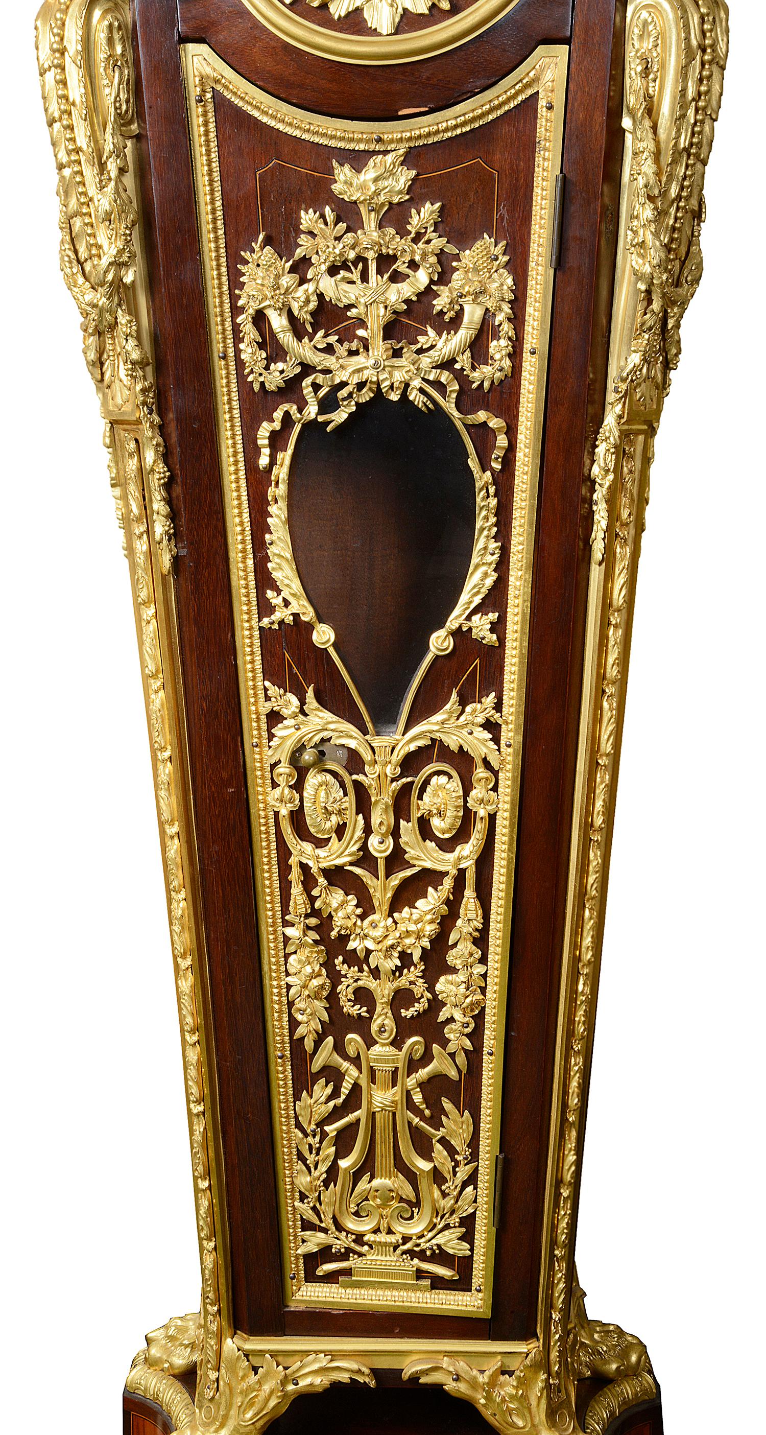 A fine 19th century french Louis XV style ormolu-mounted mahogany grandfather clock, having wonderful gilded ormolu mounts, with three cherubs in clouds around the white and black enamel dial with Roman numerals, an eight day duration movement