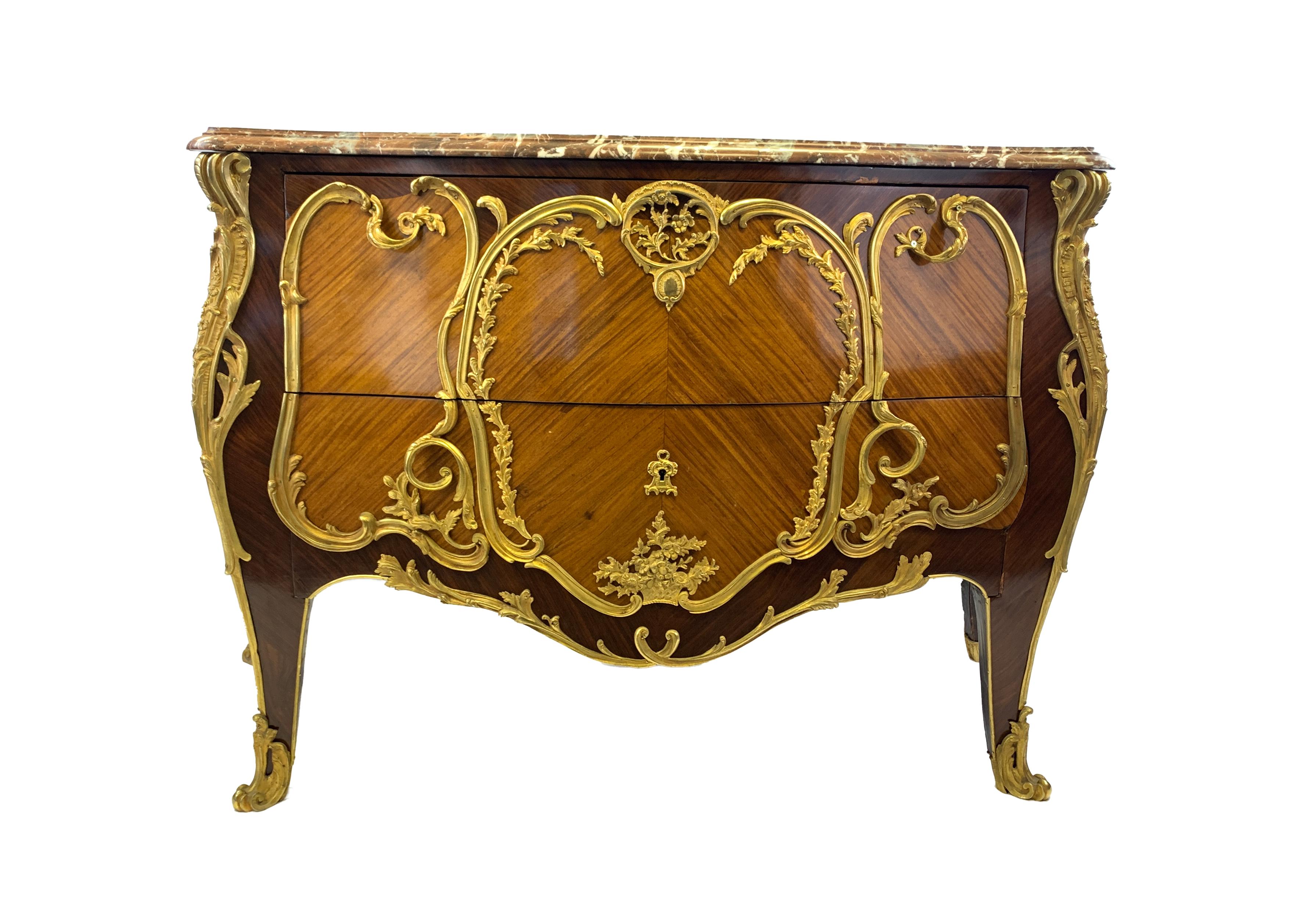 Late 19th Century, shaped marble top with moulded edge on bombe shaped commode with two long drawers, ormolu mounts and handles, resting on cabriole legs mounted with ormolu acanthus leaf feet.
 