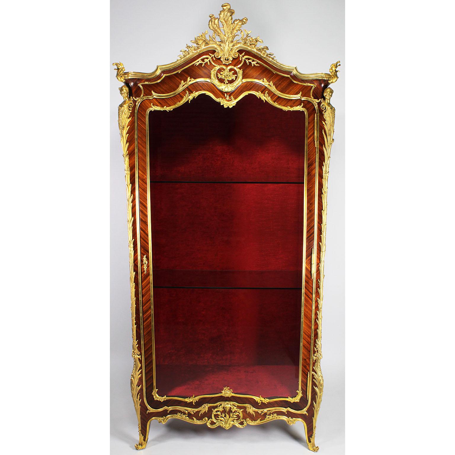 A superb quality French 19th-20th century Louis XV style ormolu-mounted kingwood, satinwood and satine single door figural vitrine by the renown Parisian master craftsman and cabinet maker François Linke, crowned with peacock royal feather and