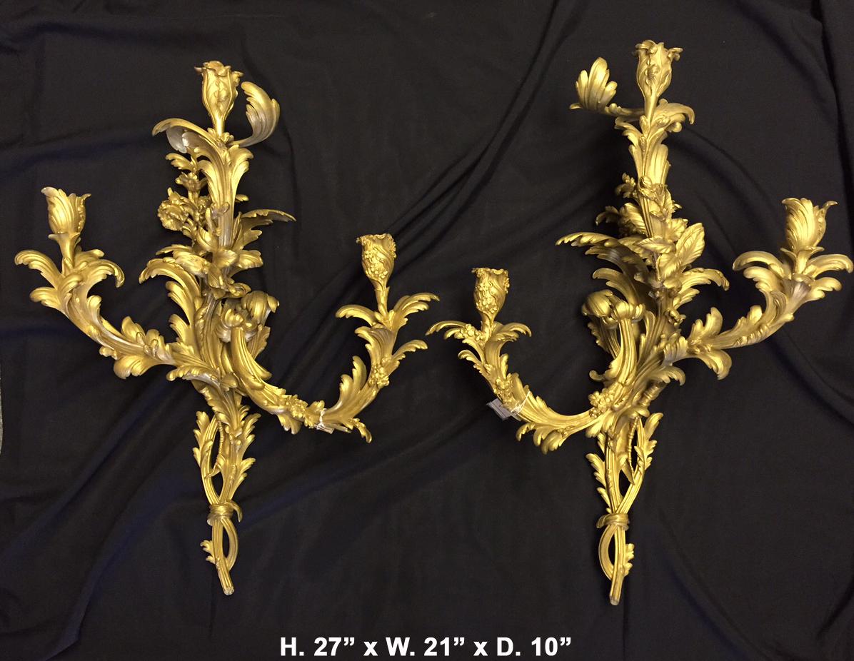 Extremely fine 19th century French Louis XV style ormolu three-light sconces.
The beautiful three-light sconces in the form of a foliate bough with three arms branching from the center shaft decorated with scrolled acanthus terminated in gilt