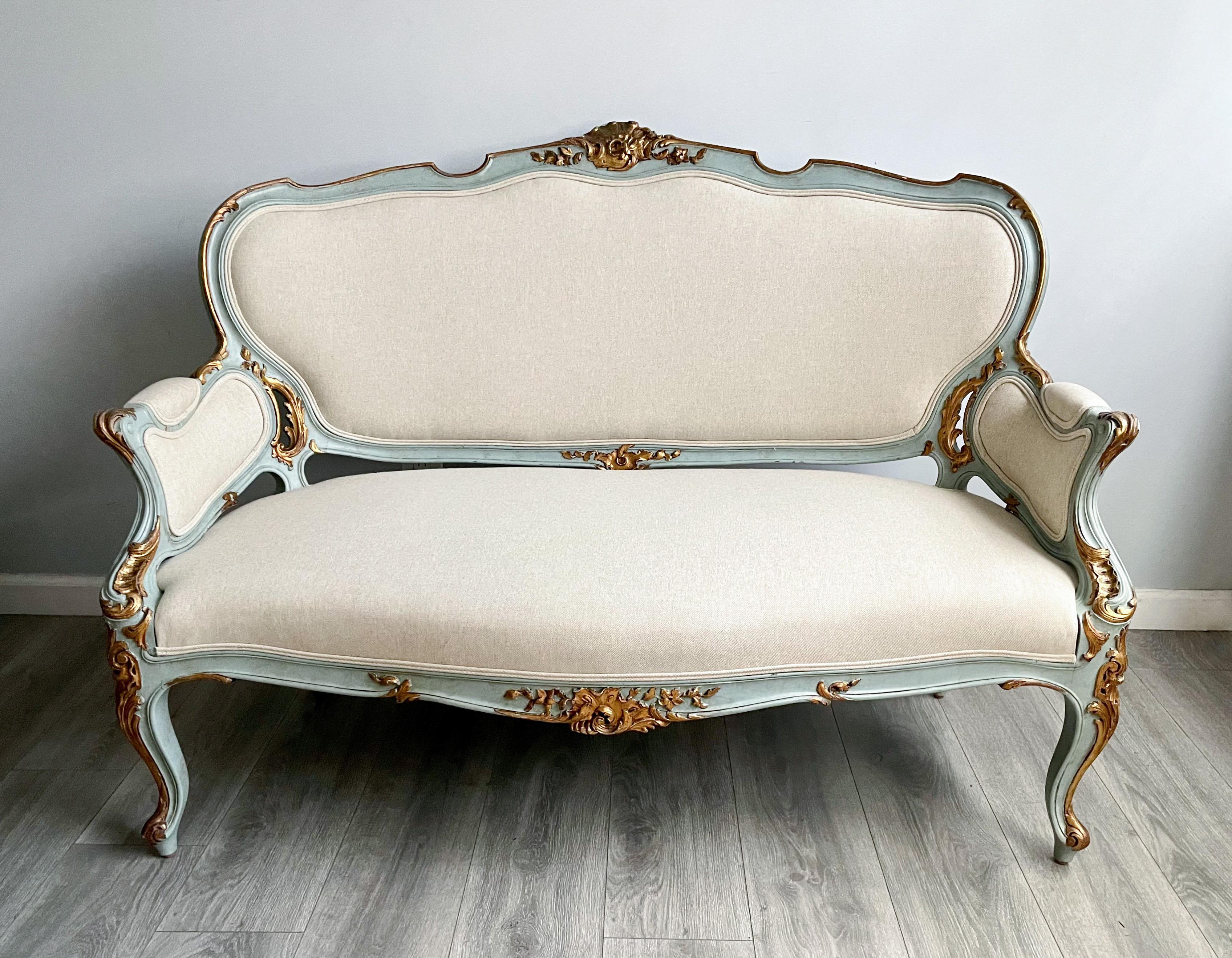 Gorgeous, 1920s French painted and parcel-gilt settee in the Louis XV style.

This French settee consists of a beautifully carved frame in a robin’s egg blue paint finish with gilt accents. New cotton linen upholstery with self-welt detailing. 

The
