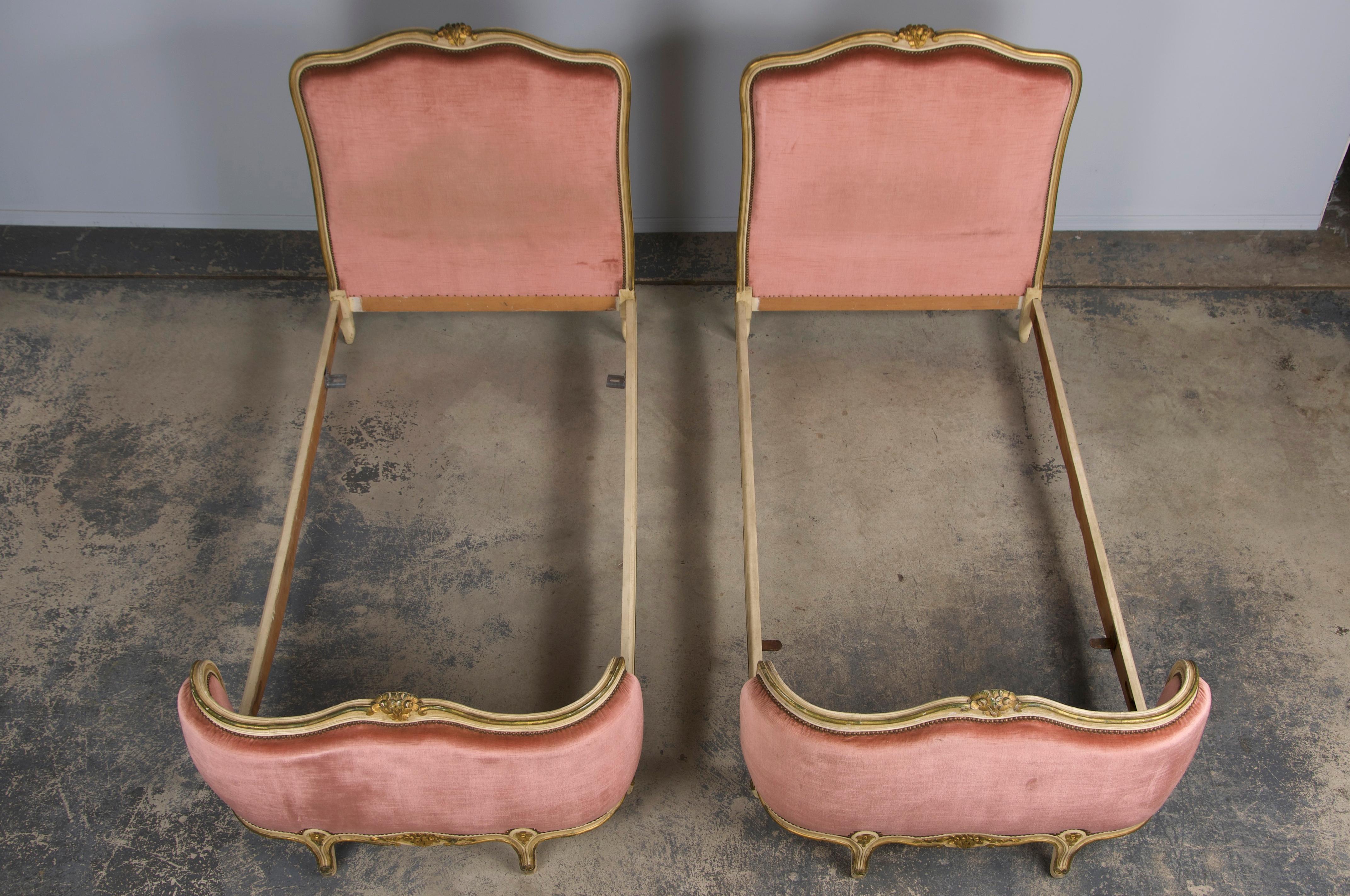An exquisite pair of early 20th-century French twin-size bed frames in the Louis XV style, sourced from Provence, France. These bed frames are crafted from solid wood with classic European proportions and include a headboard, footboard, and two