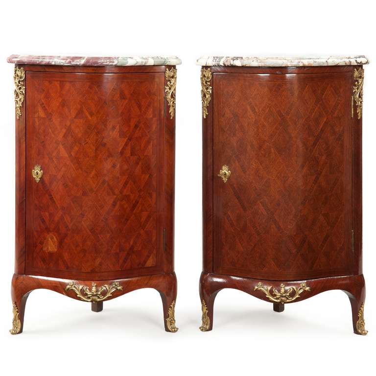 This is a fine pair of late 19th century French Louis XV style kingwood parquetry veneered ecoignures. Mottled cream and gray thick hand carved and finished original marble tops position on short dowels protruding from the top, this framed with neat