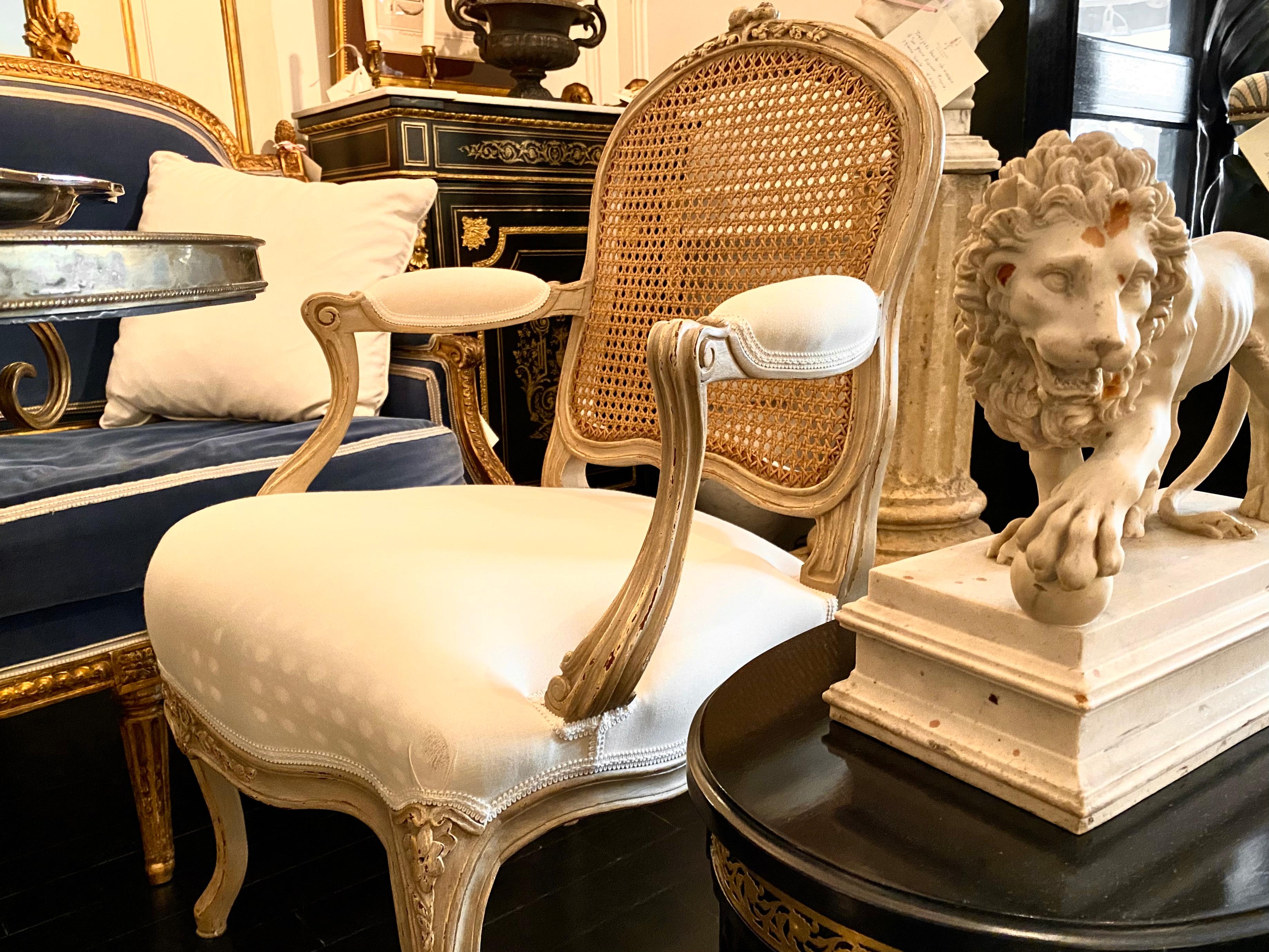 Paire de fauteuils de style Louis XV français, dossier canné.
Modèle classique à lignes pures en gris Trianon avec dossier en rotin naturel et assise rembourrée en blanc cassé.
Un total de 6 fauteuils est disponible.
