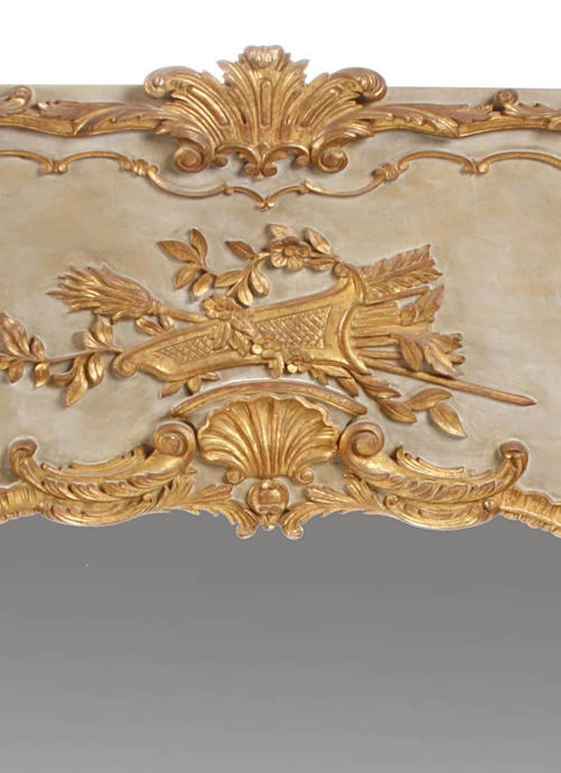 Beautiful French Louis XV style greenish grey and parcel-gilt Boiserie mirror.
Late 19th-early 20th century.

The impressive Boiserie style mirror is surmounted with a palmette cresting, conjoined with a beautifully carved giltwood cartouche of