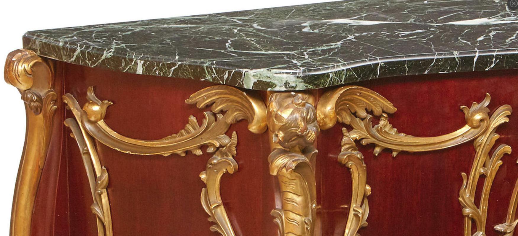 Unique and oversized French Louis XV style parcel carved-giltwood fruitwood commode-form console with marble top.
Late 19th-early 20th century. Possibly Italian.
The beautiful serpentine-fronted green marble top is over a bombe commode-form console.